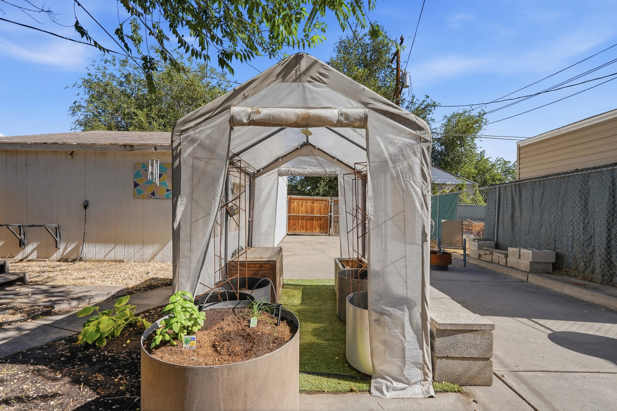 Garden area featuring a covered structure, concrete pathways, and raised planters