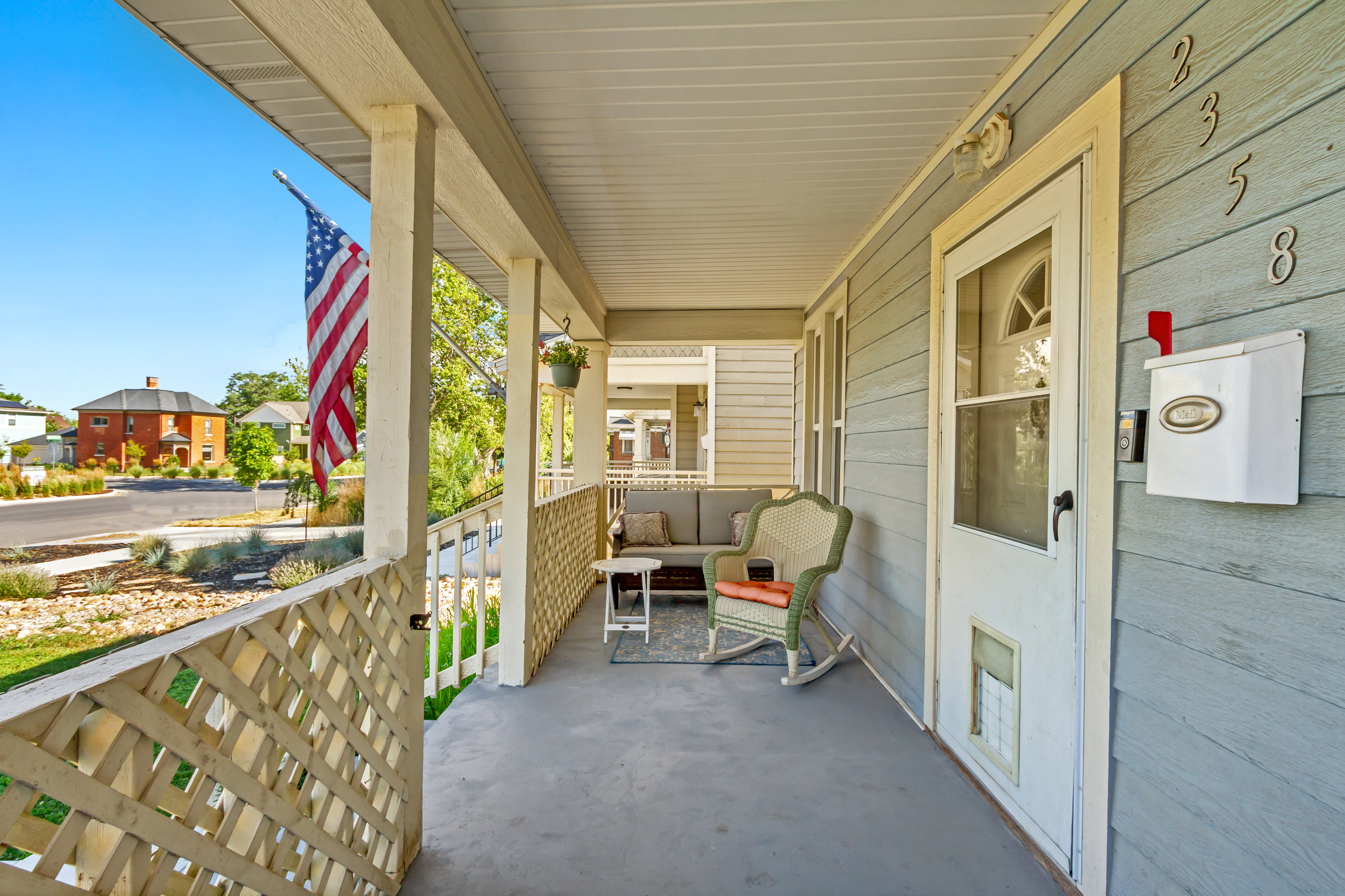 Inviting covered porch with lattice railing and beadboard ceiling