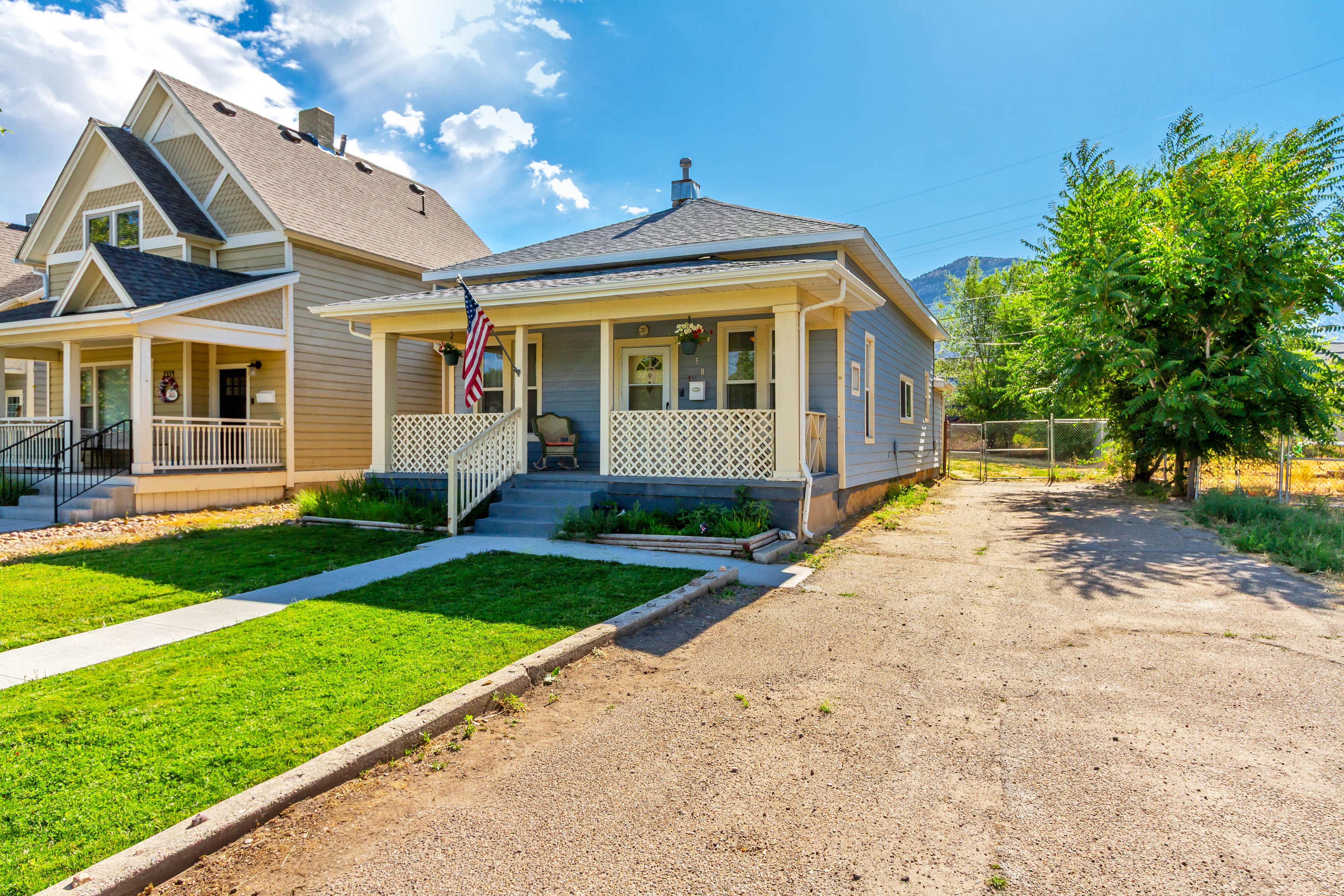 Light blue exterior with white trim and a covered front porch featuring white lattice railing