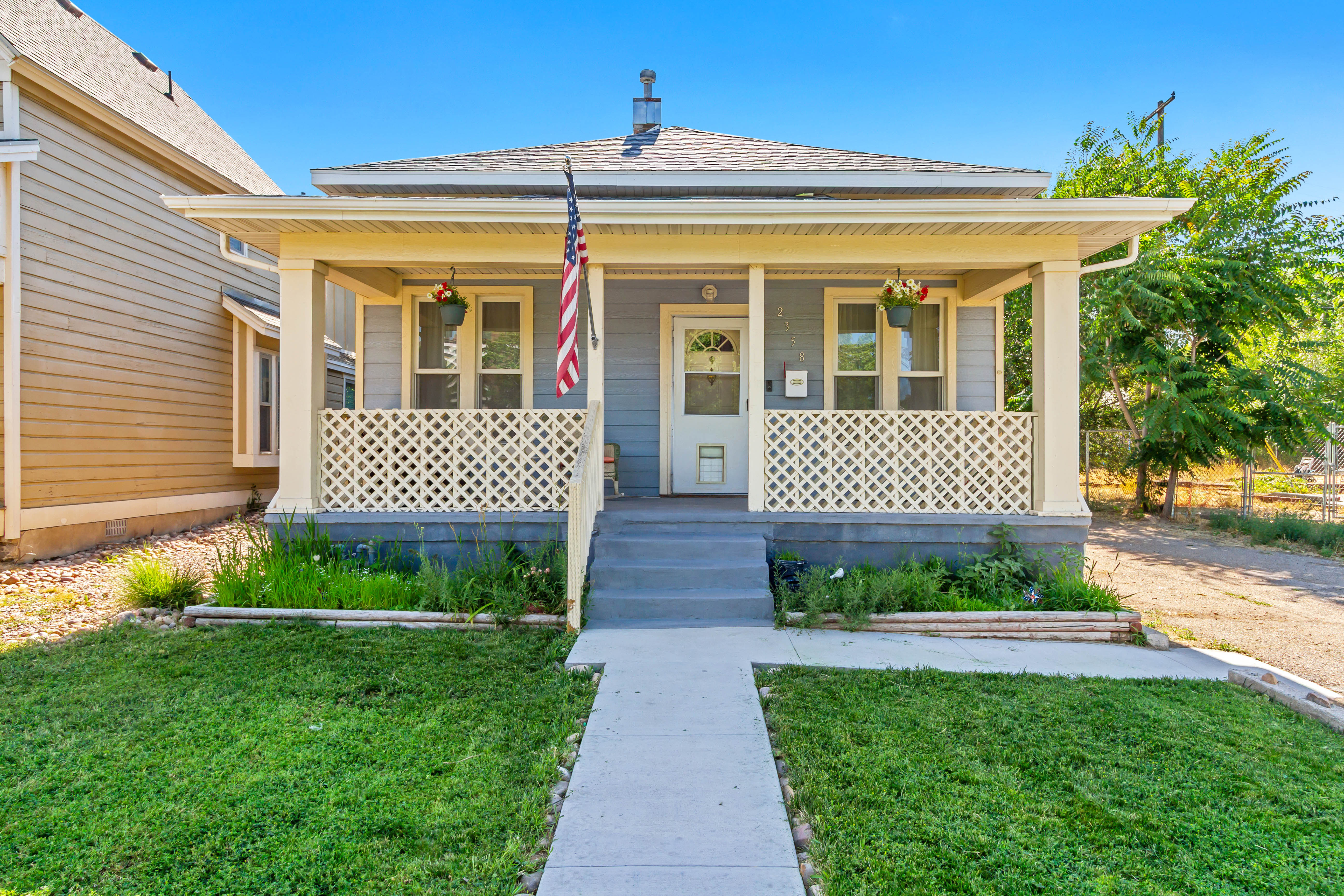 Inviting bungalow-style residence featuring a prominent covered porch with decorative lattice railing