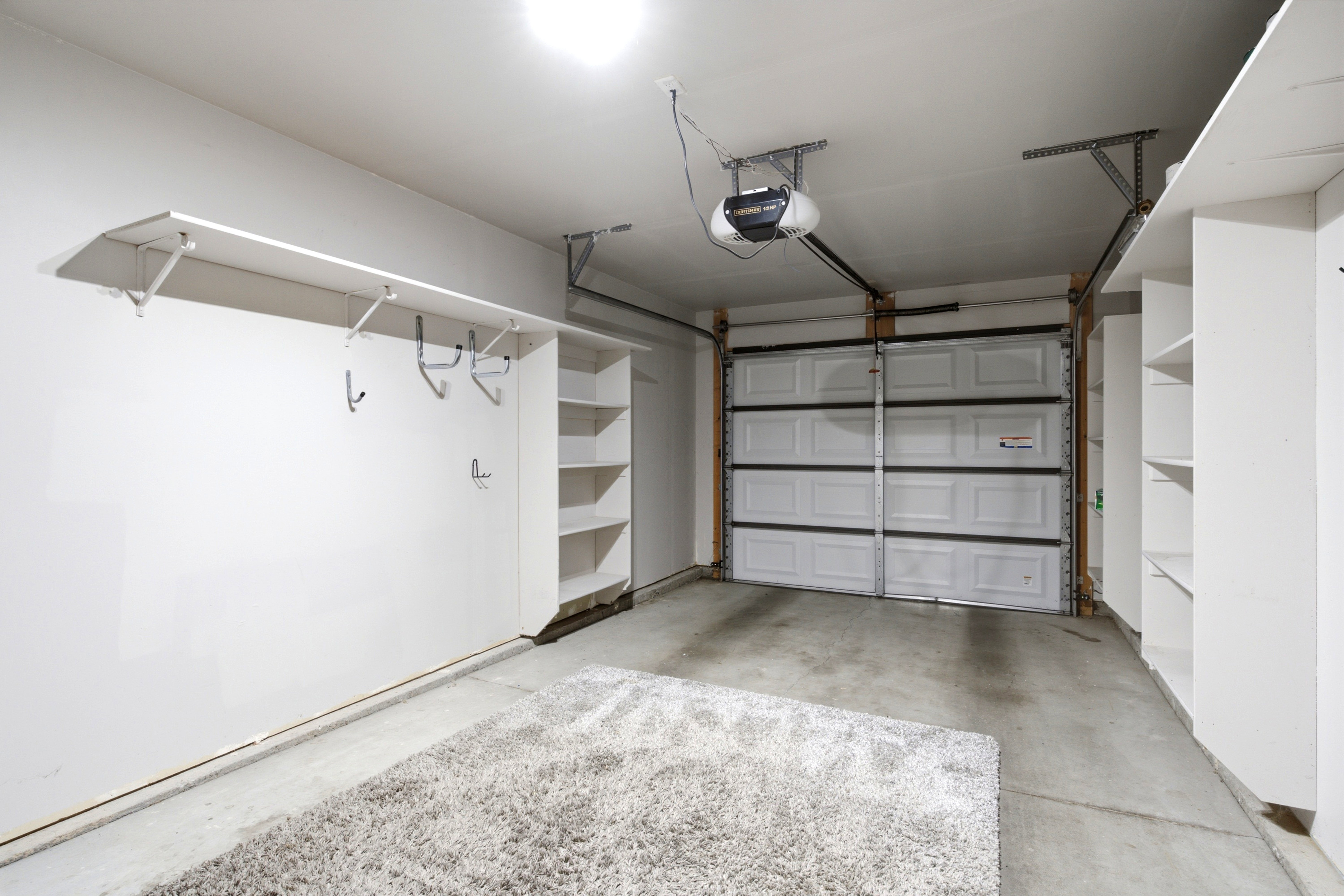 Integrated garage storage solutions featuring shelving units and a wall-mounted rack