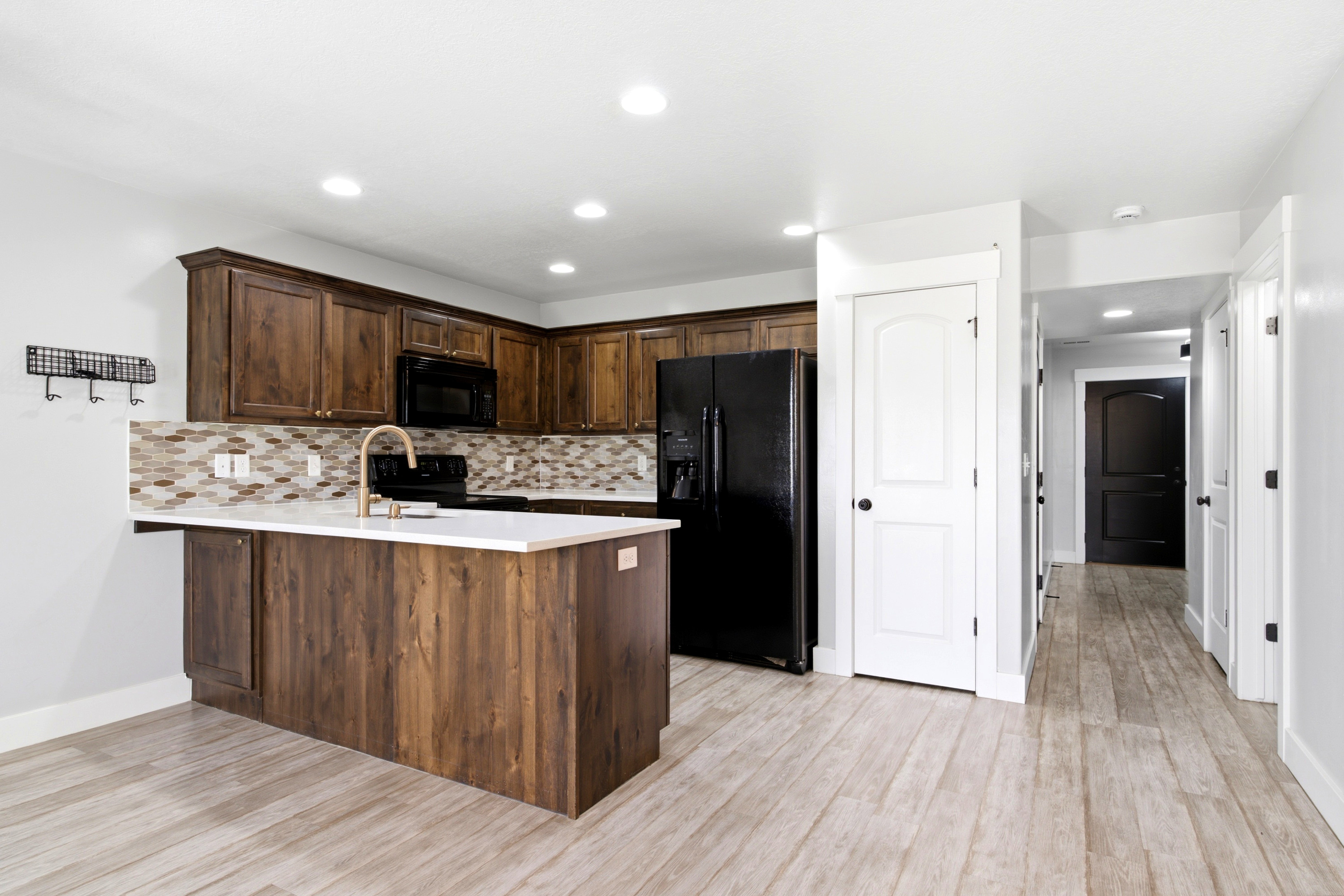 Kitchen featuring wood-finish cabinetry, white countertops, and a mosaic tile backsplash