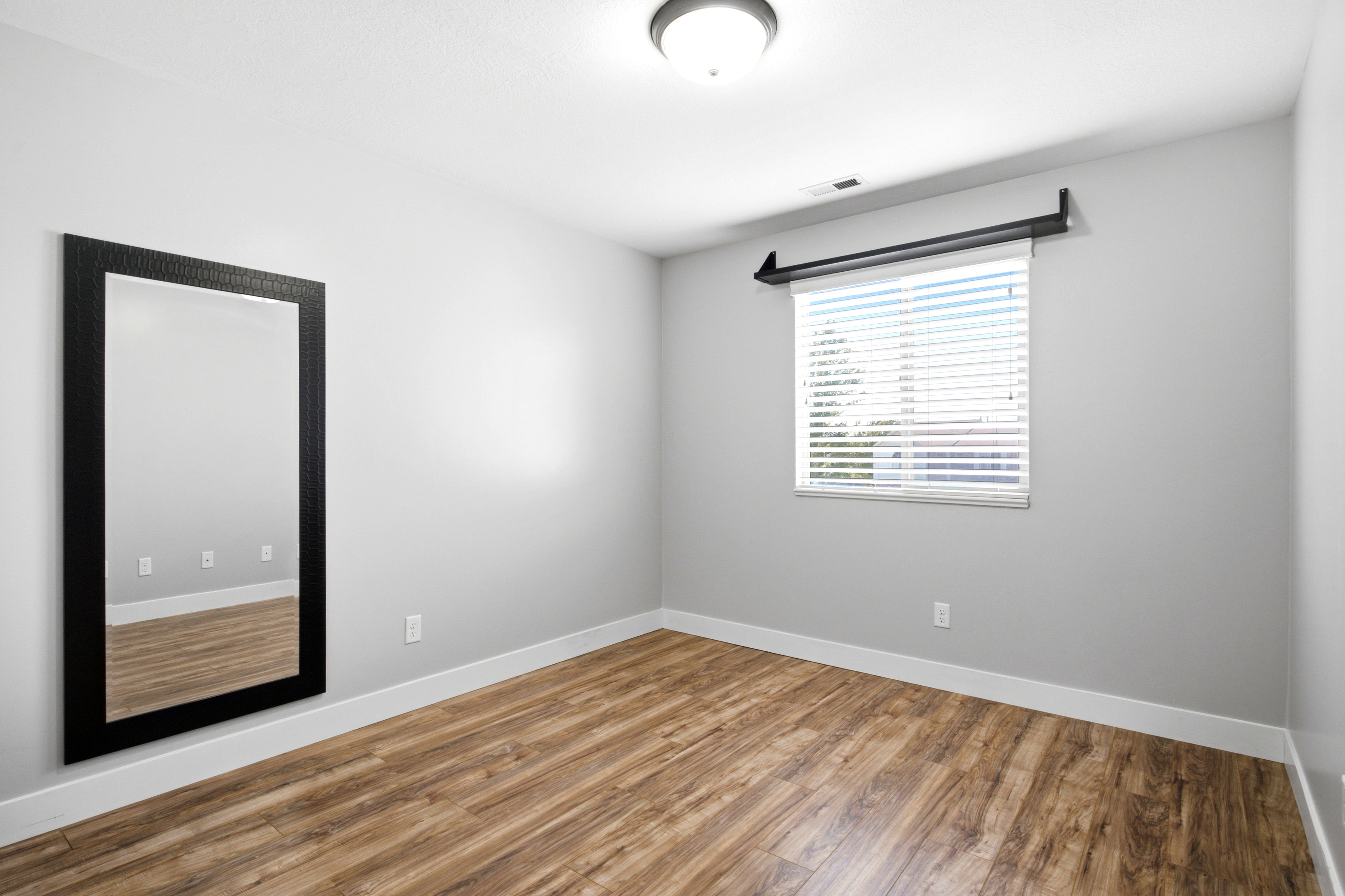 Light gray walls complement the wood-finish flooring in this room