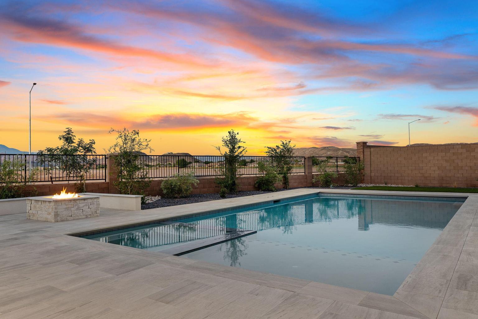 Rectangular swimming pool with light-colored coping and surrounding tile-look patio