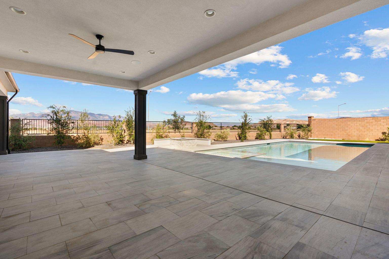 Expansive covered patio featuring a ceiling fan and recessed lighting, overlooking a rectangular pool