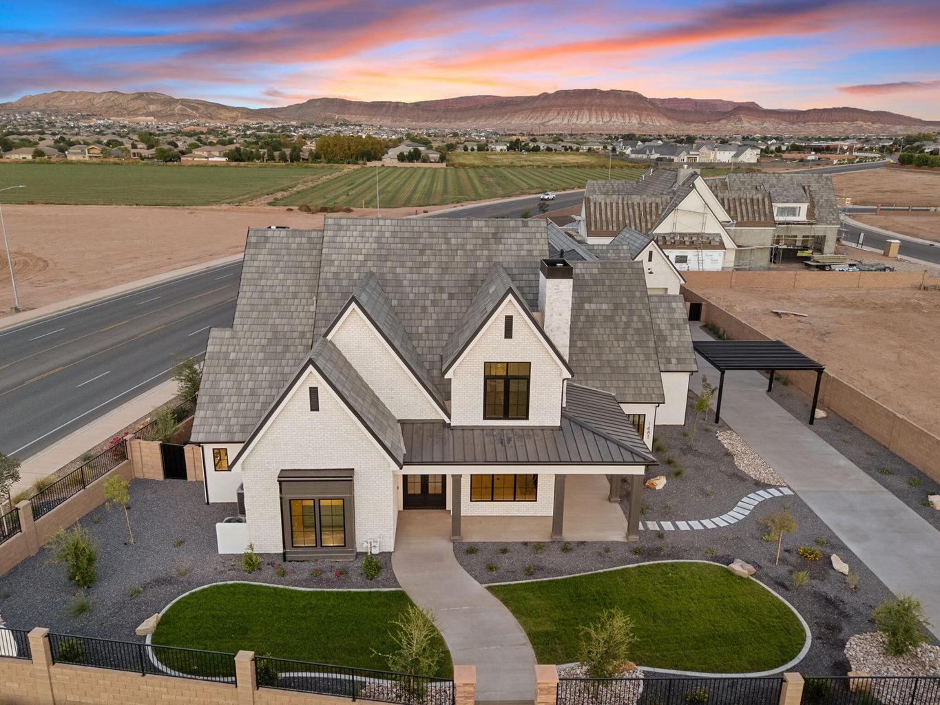 Distinctive modern farmhouse exterior with white stucco siding and dark-trimmed windows