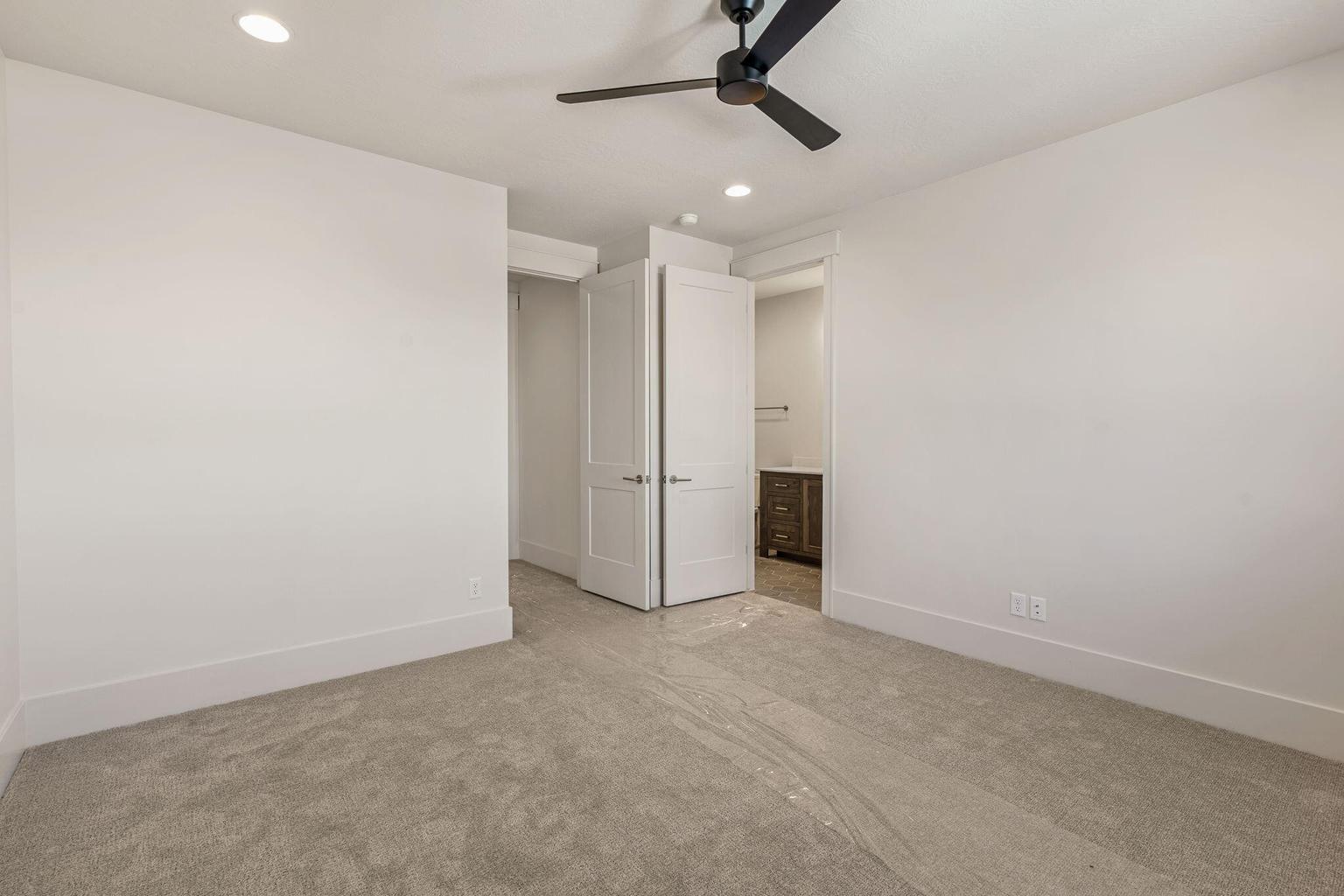 Carpeted room featuring a ceiling fan with integrated lighting, recessed ceiling lights, and white baseboards