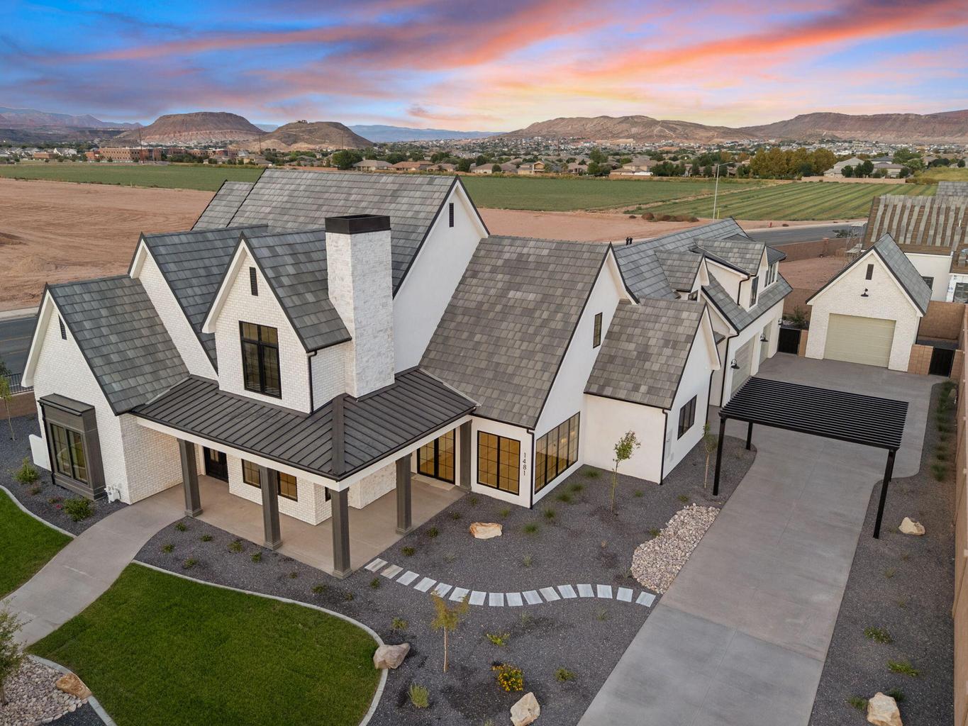 Contemporary white brick residence featuring multiple gables and a prominent brick chimney