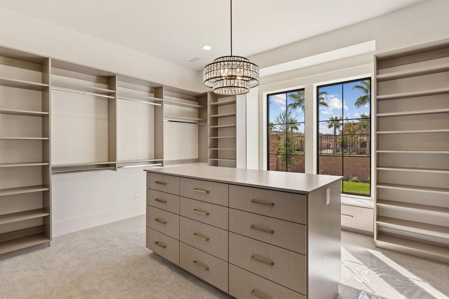 Custom closet system featuring extensive shelving, hanging rods, and a central island with multiple drawers