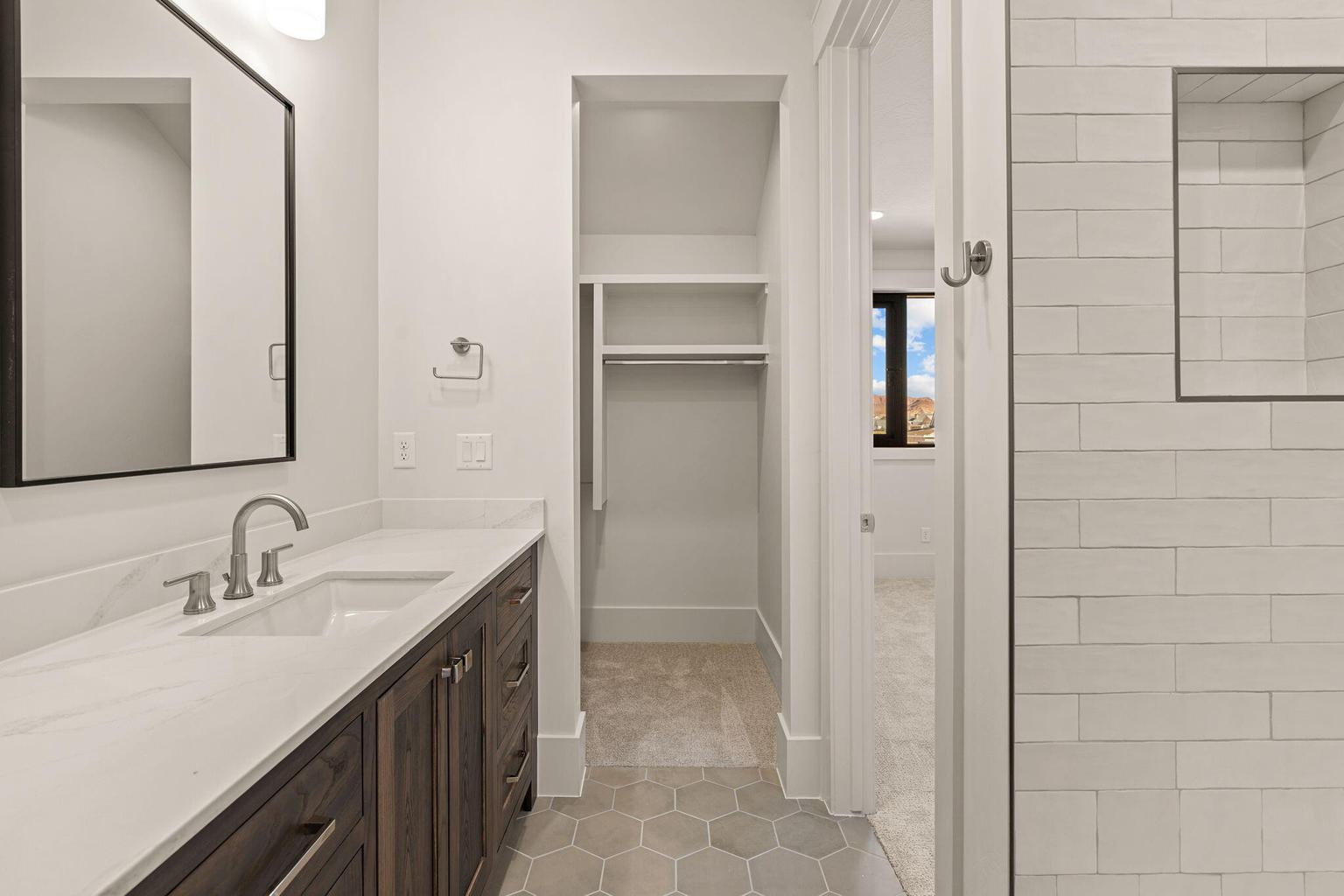 Bathroom vanity featuring a quartz countertop, integrated rectangular sink, and brushed nickel faucet