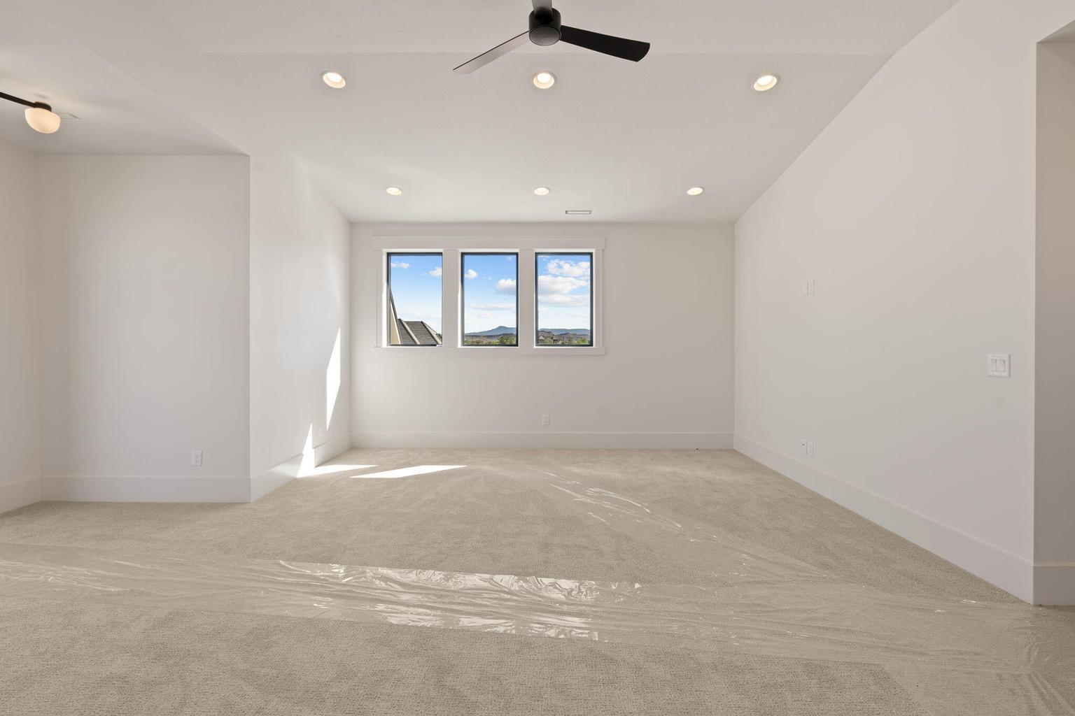 Spacious room featuring neutral carpeting and white walls