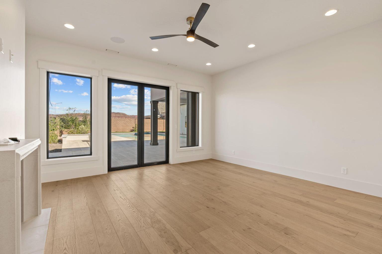 Spacious room featuring light wood-finish flooring, recessed lighting, and a modern ceiling fan