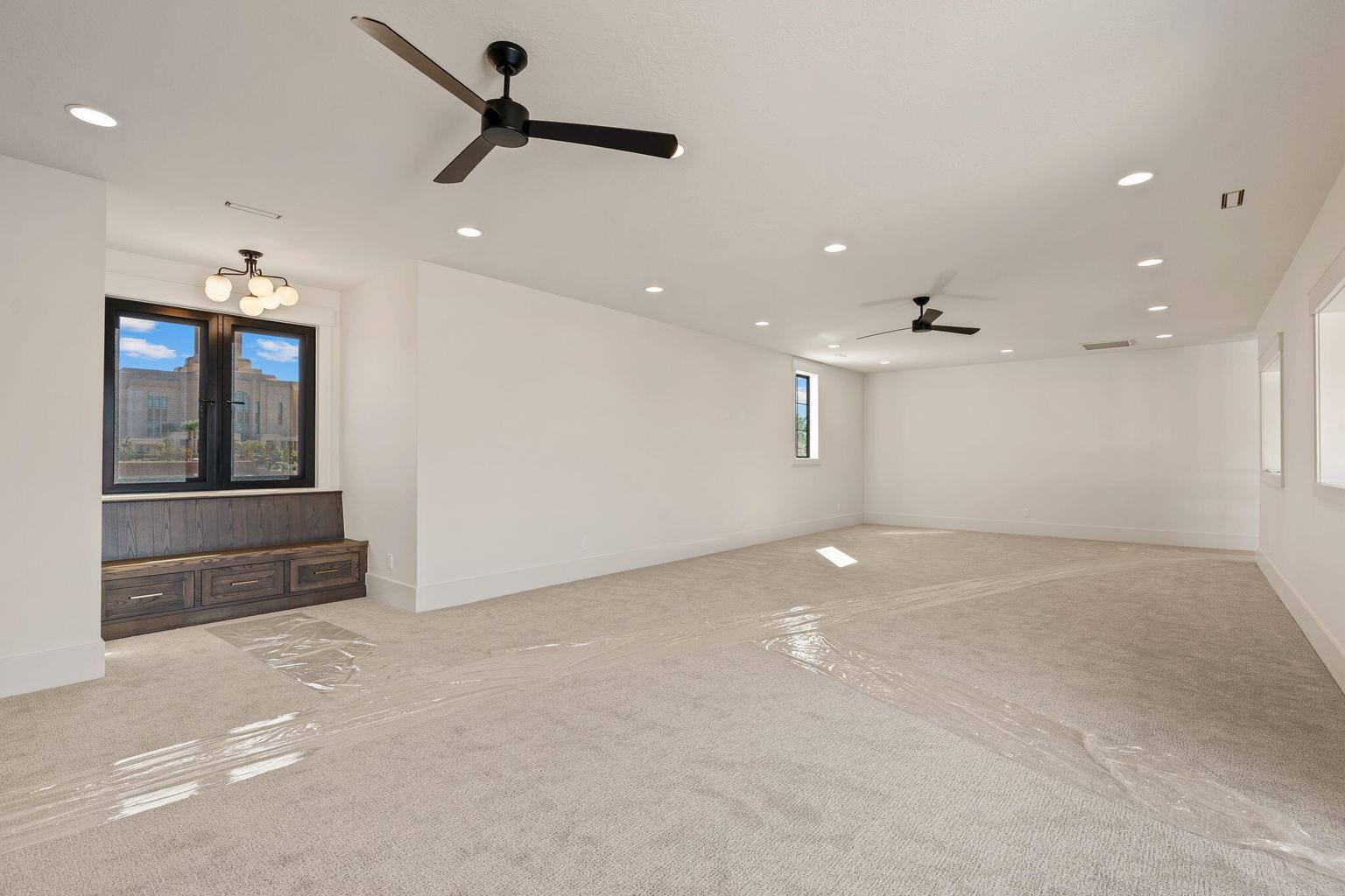 Spacious room featuring neutral carpeting and white walls