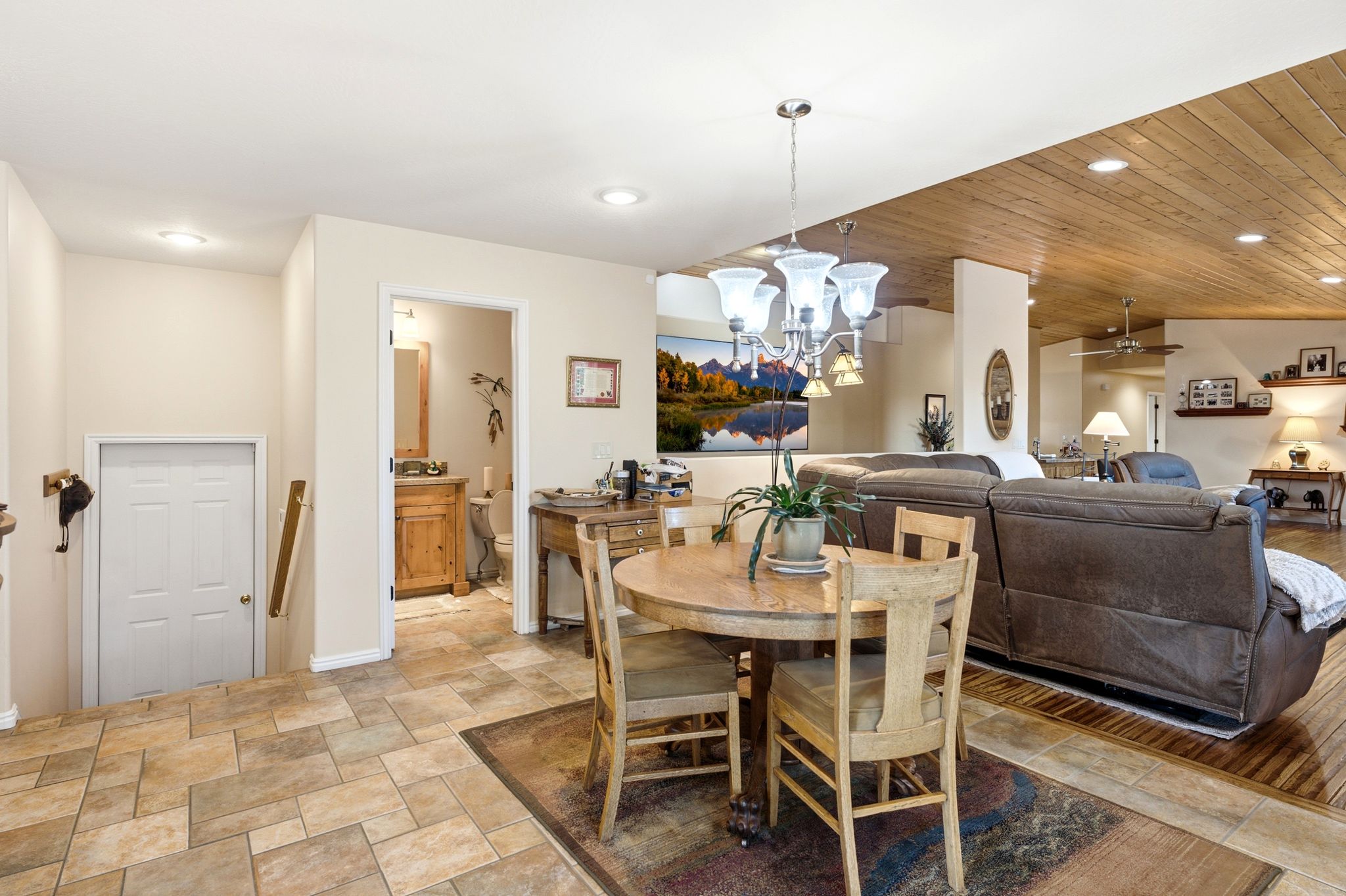 Open-concept living space with multi-toned tile flooring, wood-finish flooring, a wood-paneled ceiling, and recessed lighting