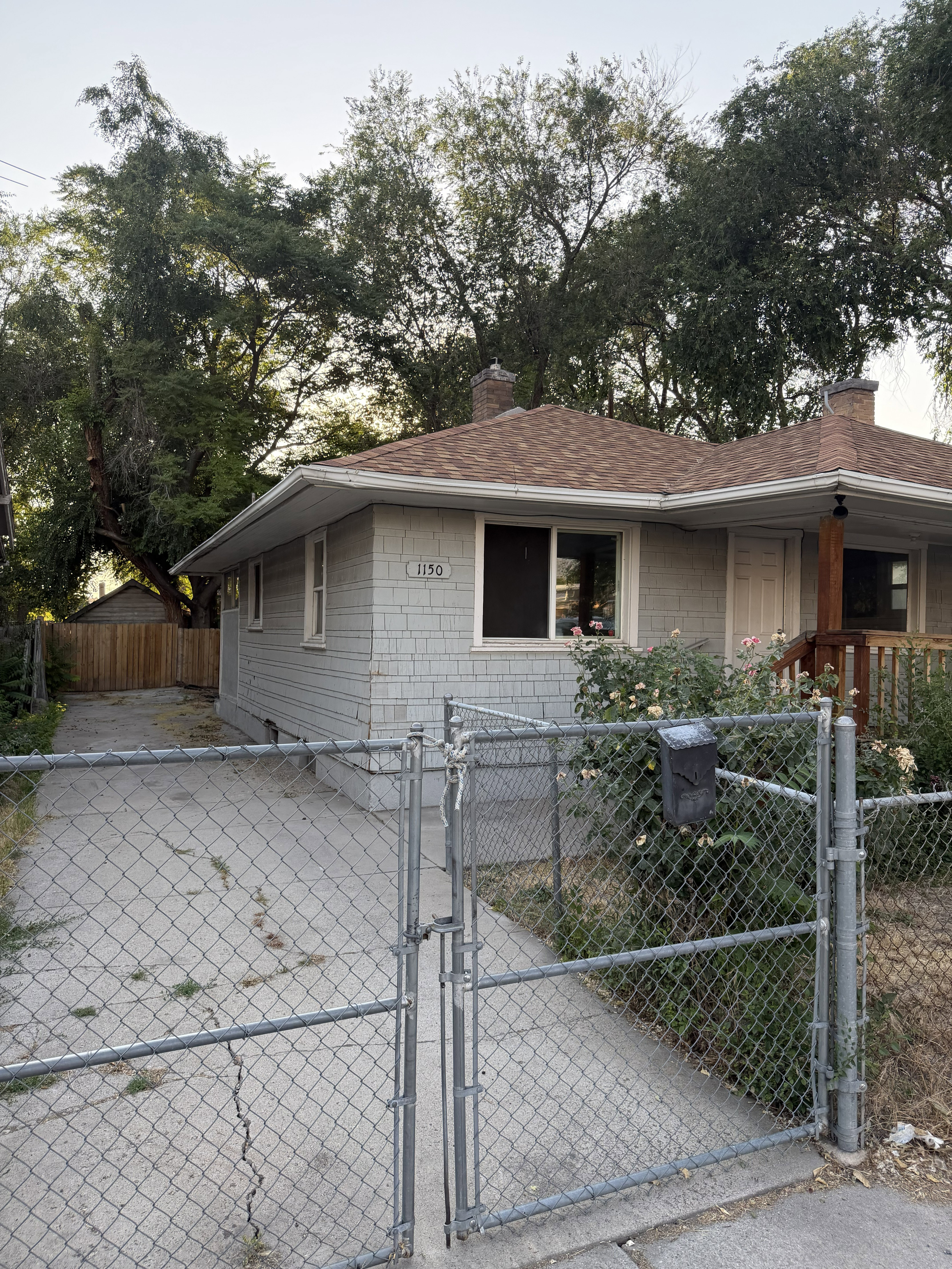 Single-story residence featuring light gray shingle siding and a brown asphalt shingle roof