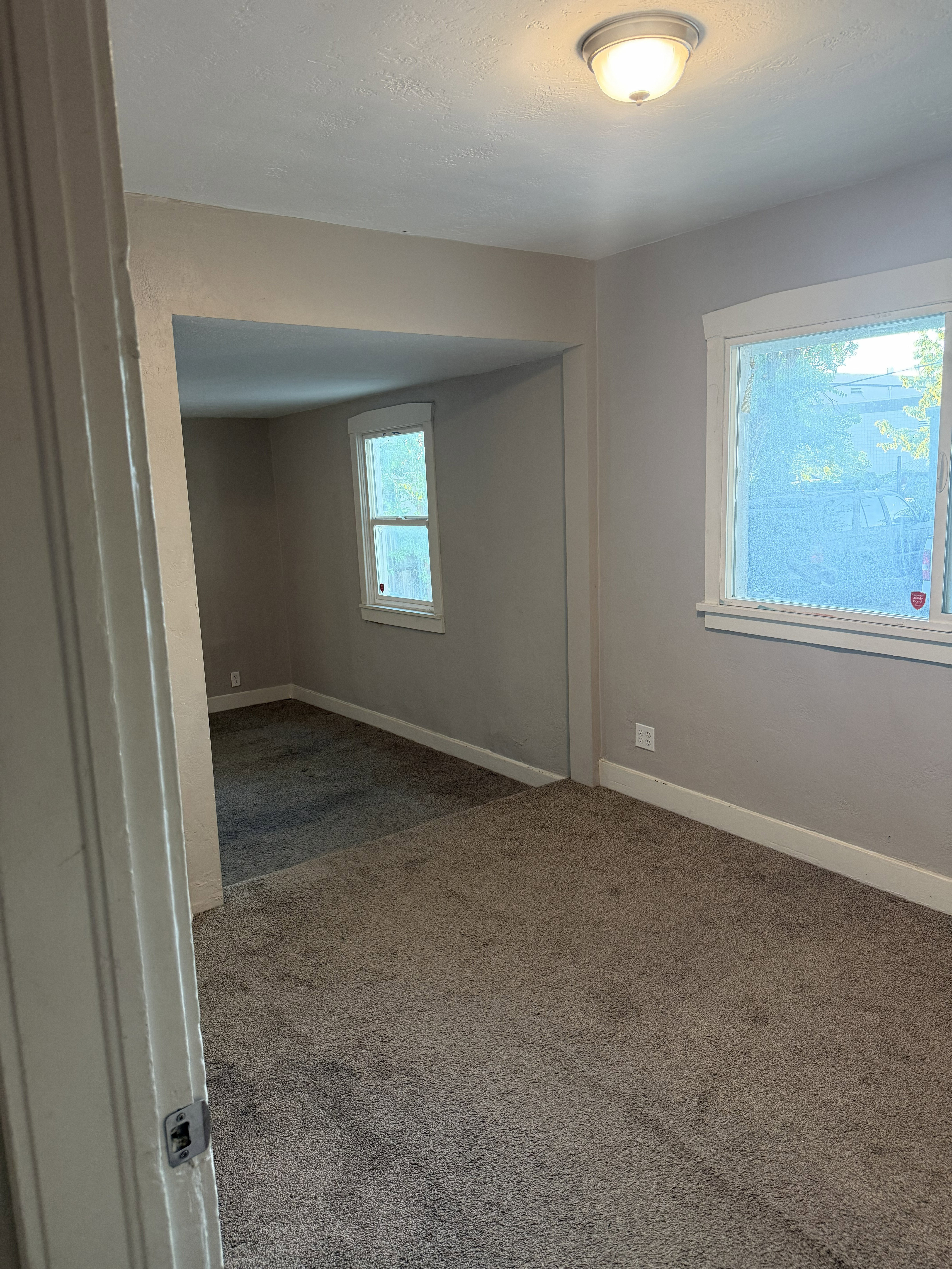 Carpeted interior space with neutral wall tones and white baseboards
