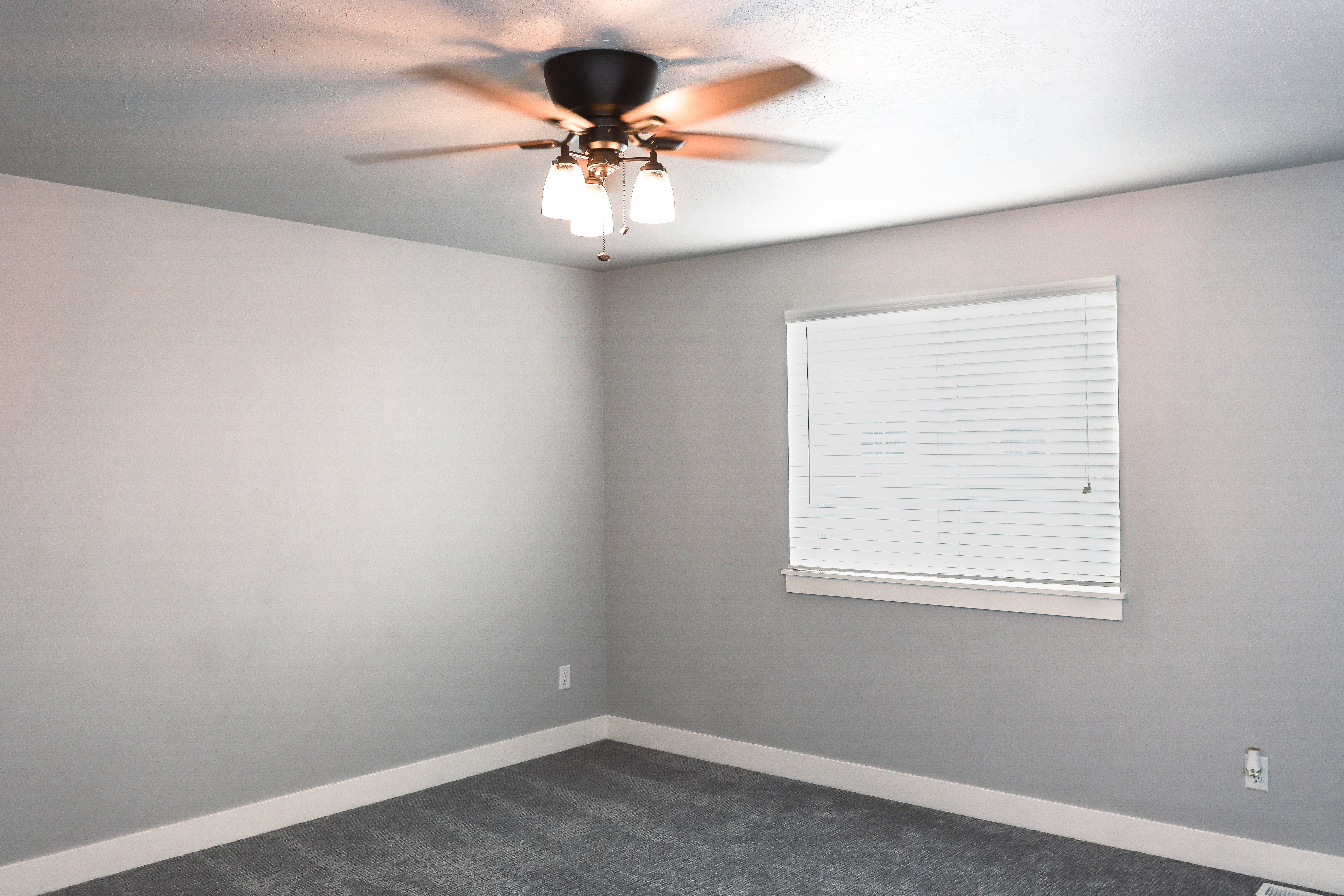 Room featuring gray wall paint, white baseboards, and dark gray carpeting