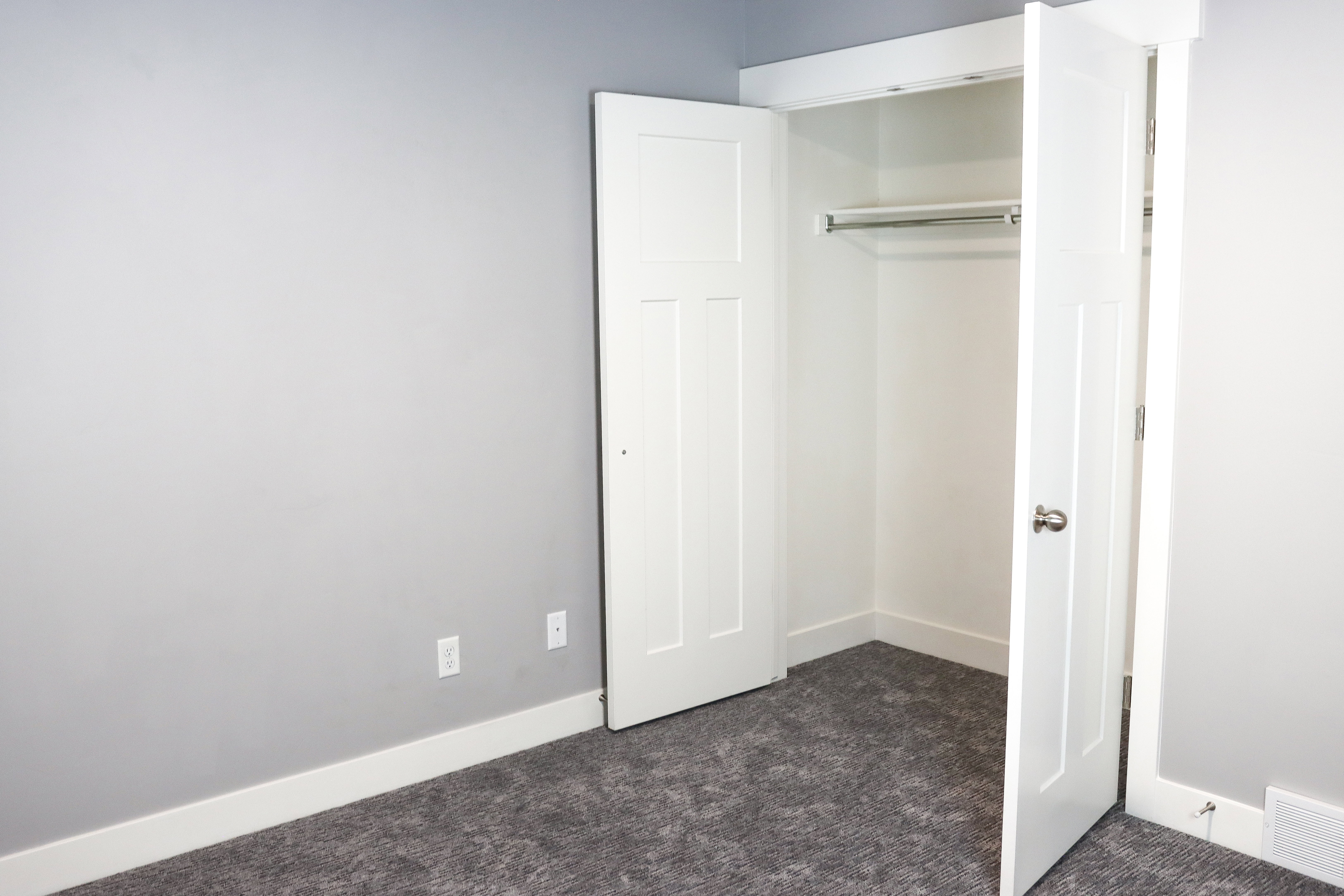 Recessed closet featuring bi-fold doors, white trim, and integrated hanging rod