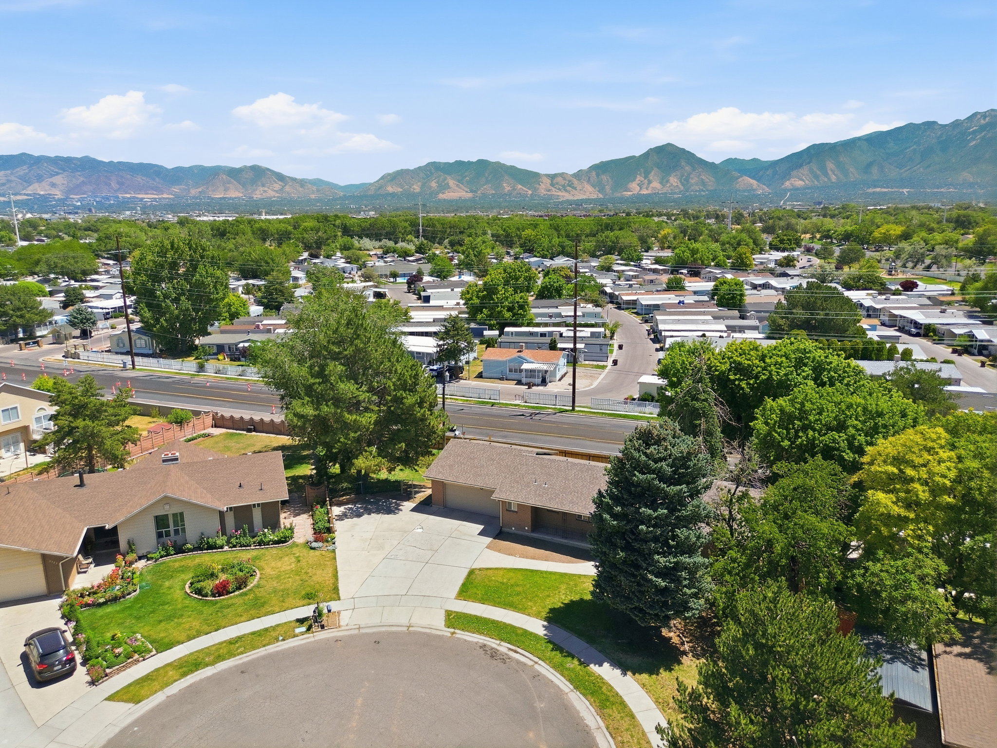 Aerial perspective showcasing a single-story home with a brown shingle roof and a concrete driveway