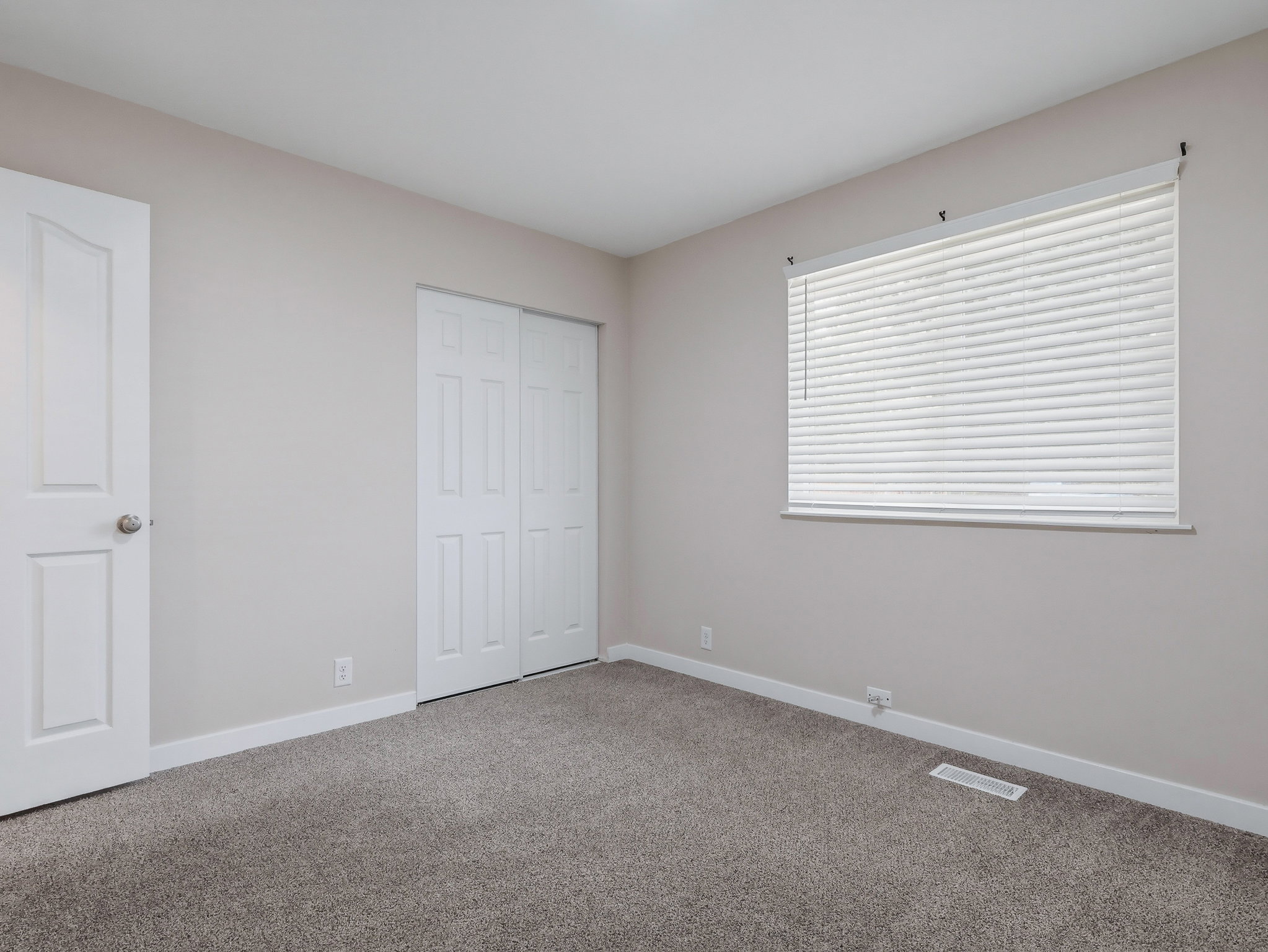 Neutral-toned walls complement the gray carpet flooring