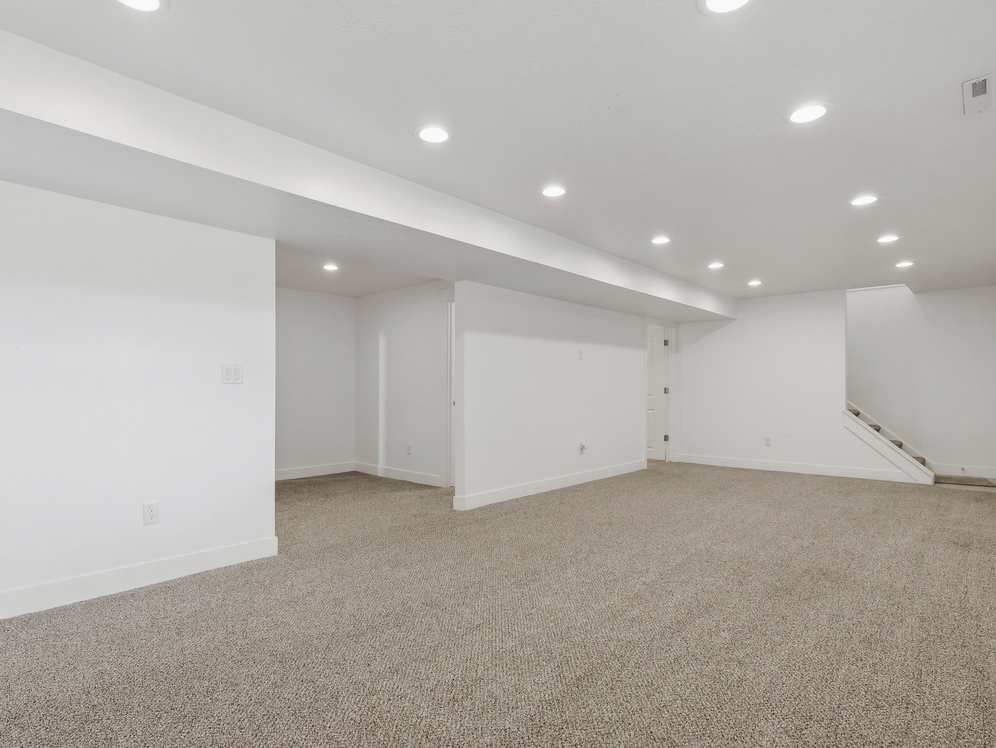 Expansive carpeted area featuring recessed lighting, white walls, and white trim