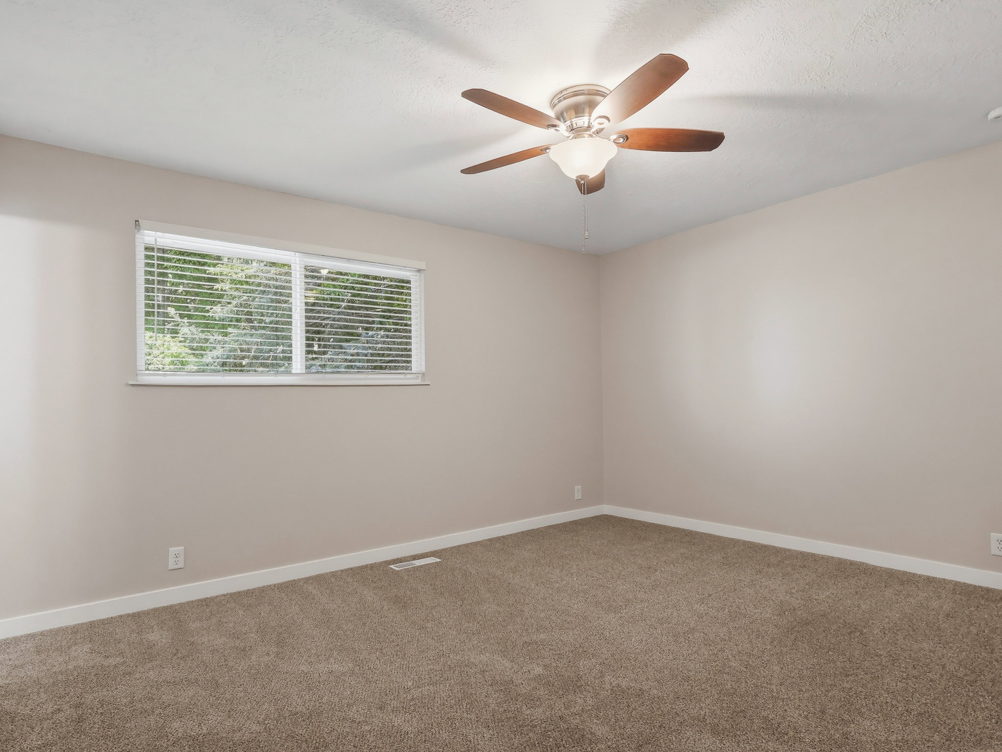 Room featuring a ceiling fan with integrated lighting, neutral-toned carpeting, and a window with blinds