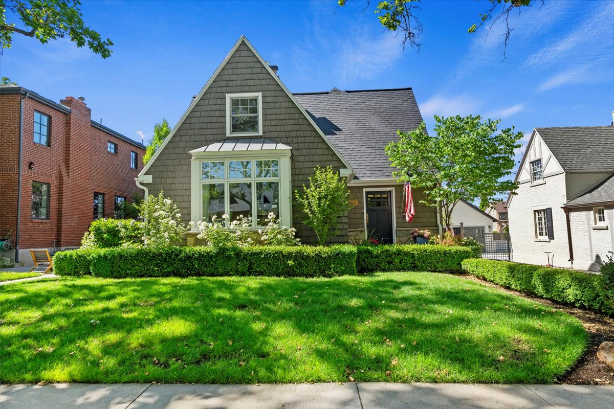Shingled exterior with a prominent bay window, dormer, and dark roof