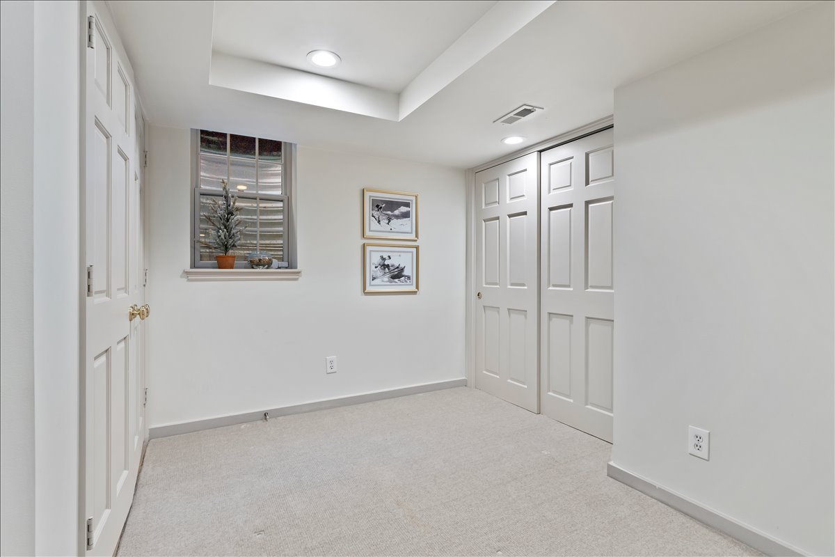 Carpeted room featuring a double-pane window, recessed lighting, white six-panel door, and a two-panel sliding closet door