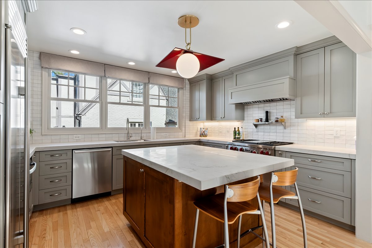 Kitchen with a central island featuring a light-toned countertop