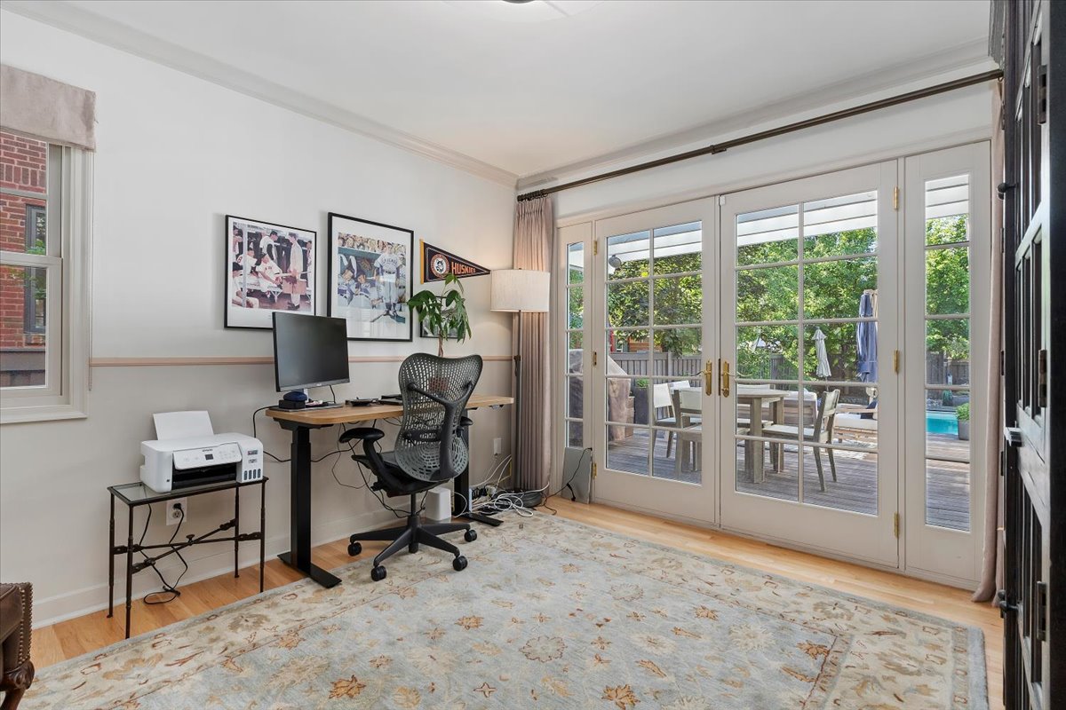 Room featuring light wood-finish flooring, white walls with a chair rail, and crown molding