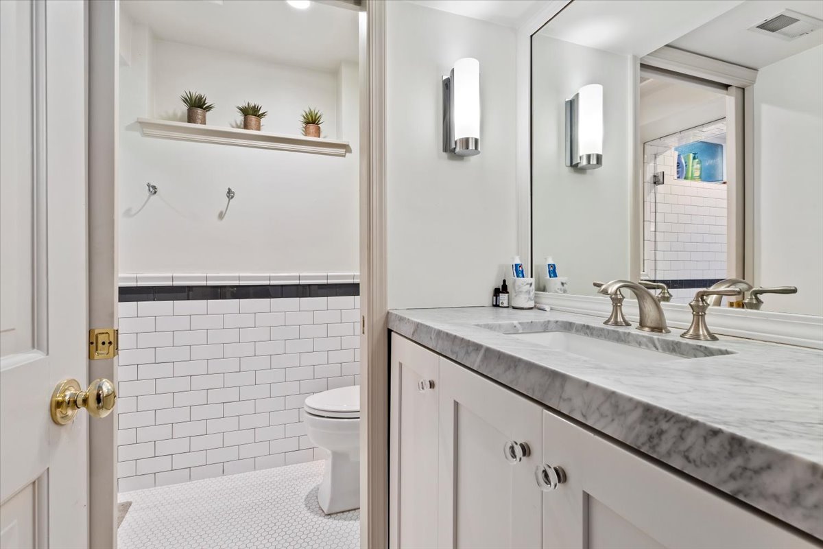 Bathroom featuring a double vanity with a stone countertop, dual undermount sinks, and brushed nickel faucets