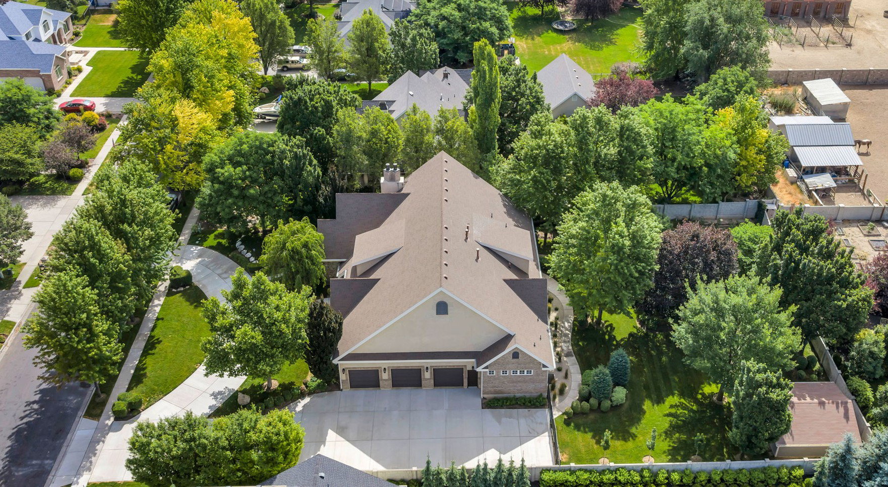 Expansive property featuring a 3-car garage, mature landscaping, and a substantial driveway