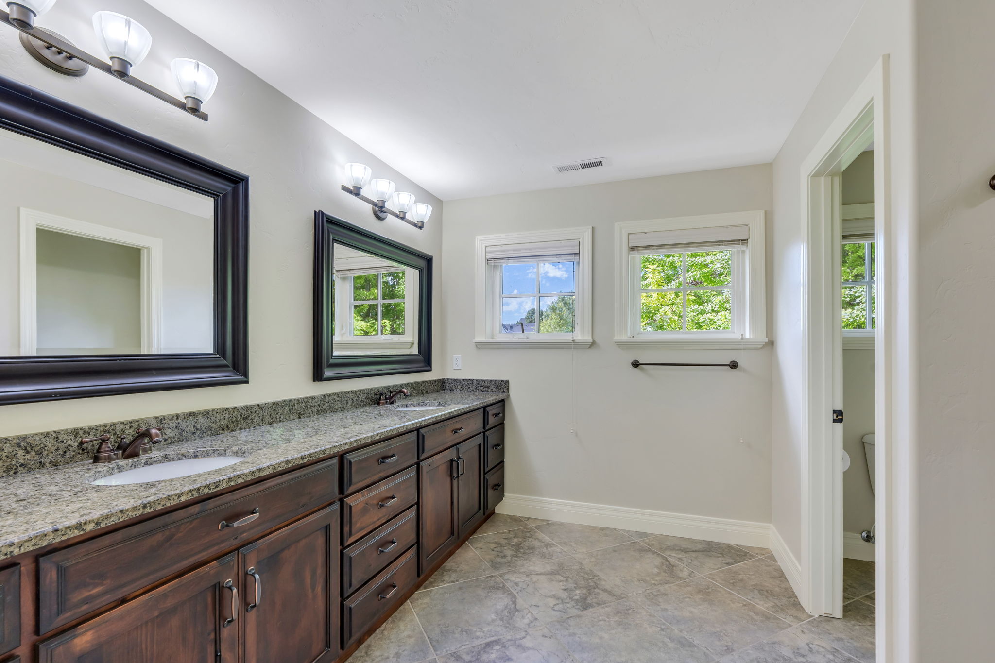 Bathroom with double sinks next to two large bedrooms and flex space