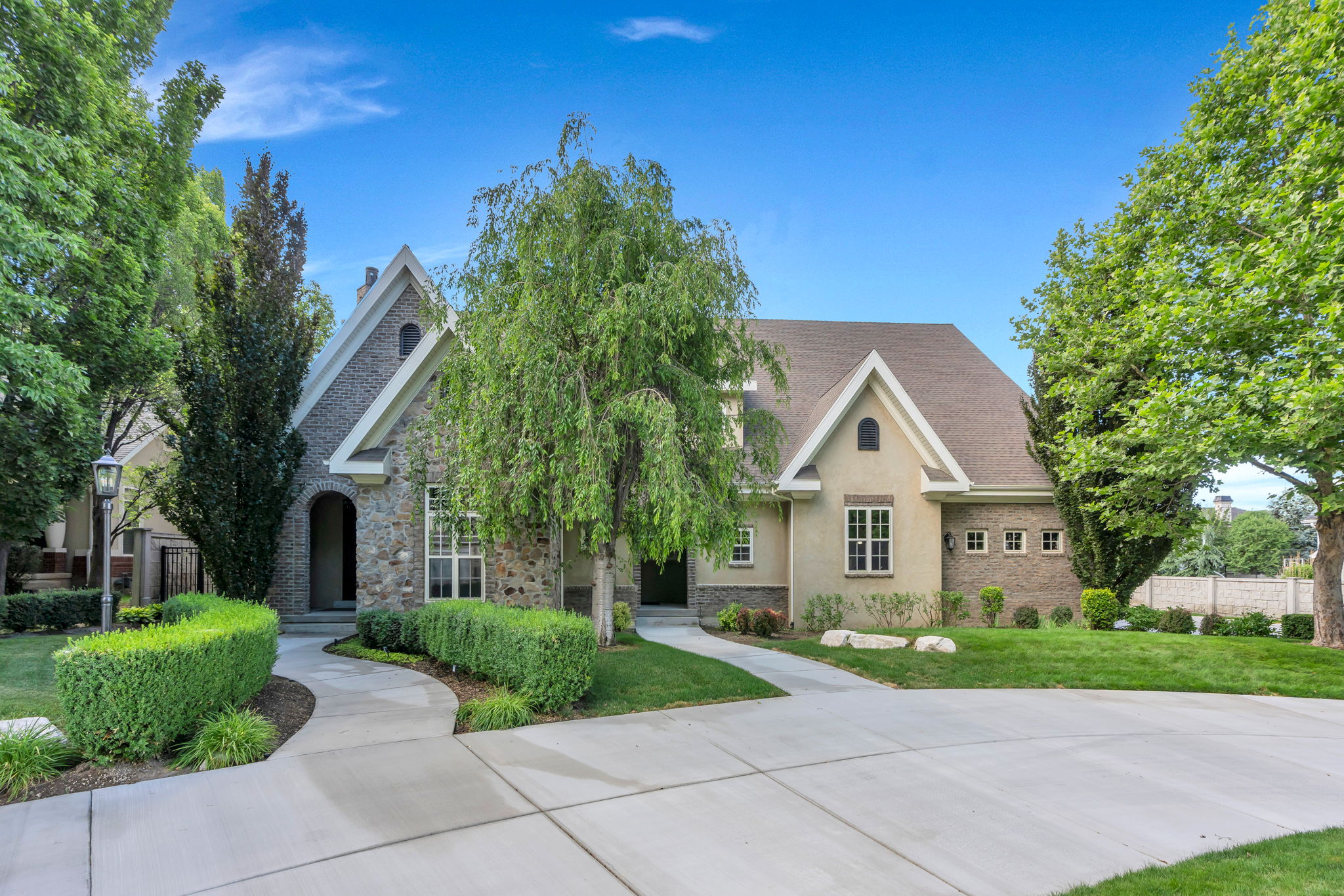 Stone, stucco and brick exterior featuring a gabled roofline
