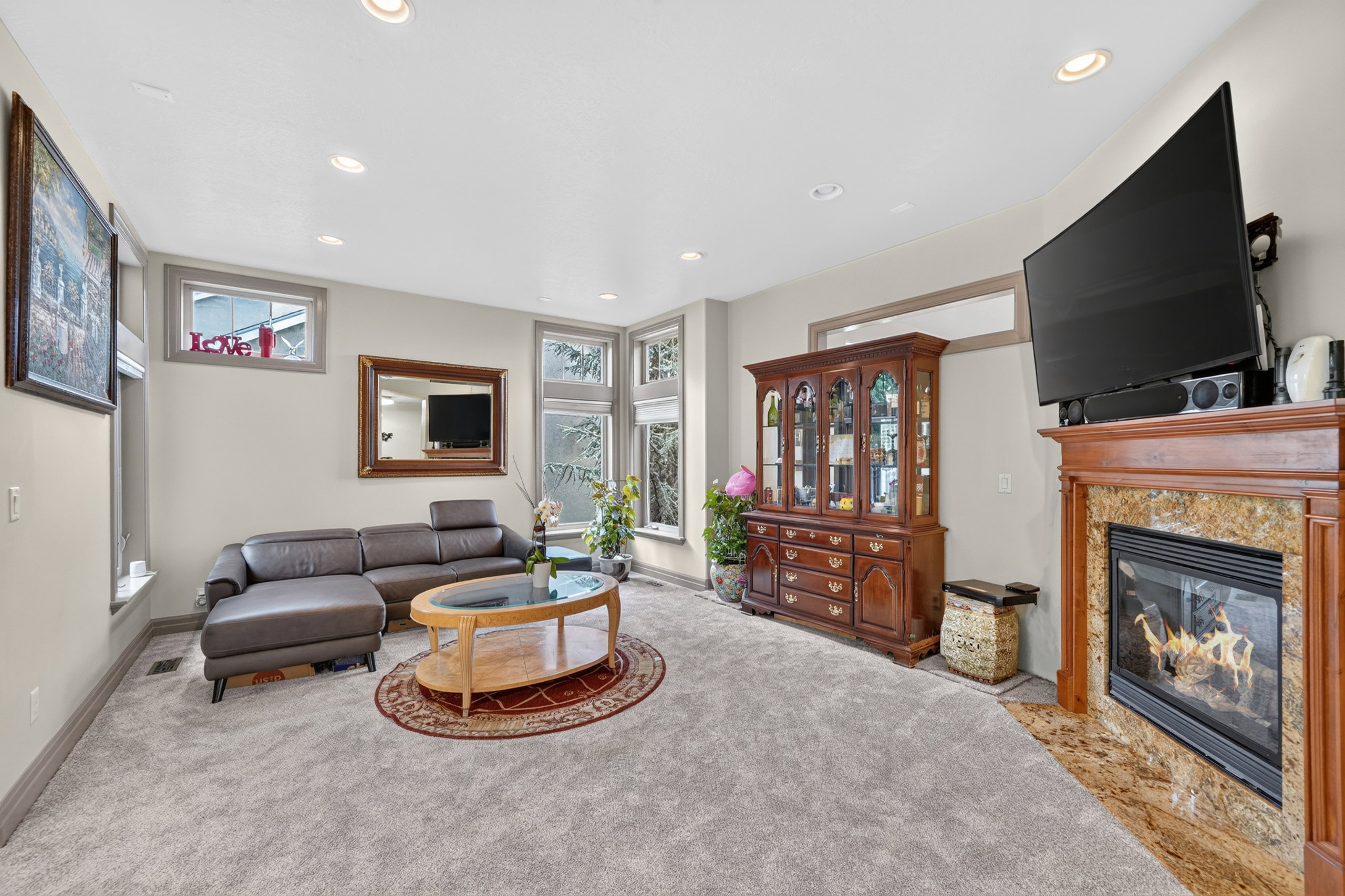 Living area featuring wall-to-wall carpeting and a fireplace with a light-toned stone surround and a wood mantel