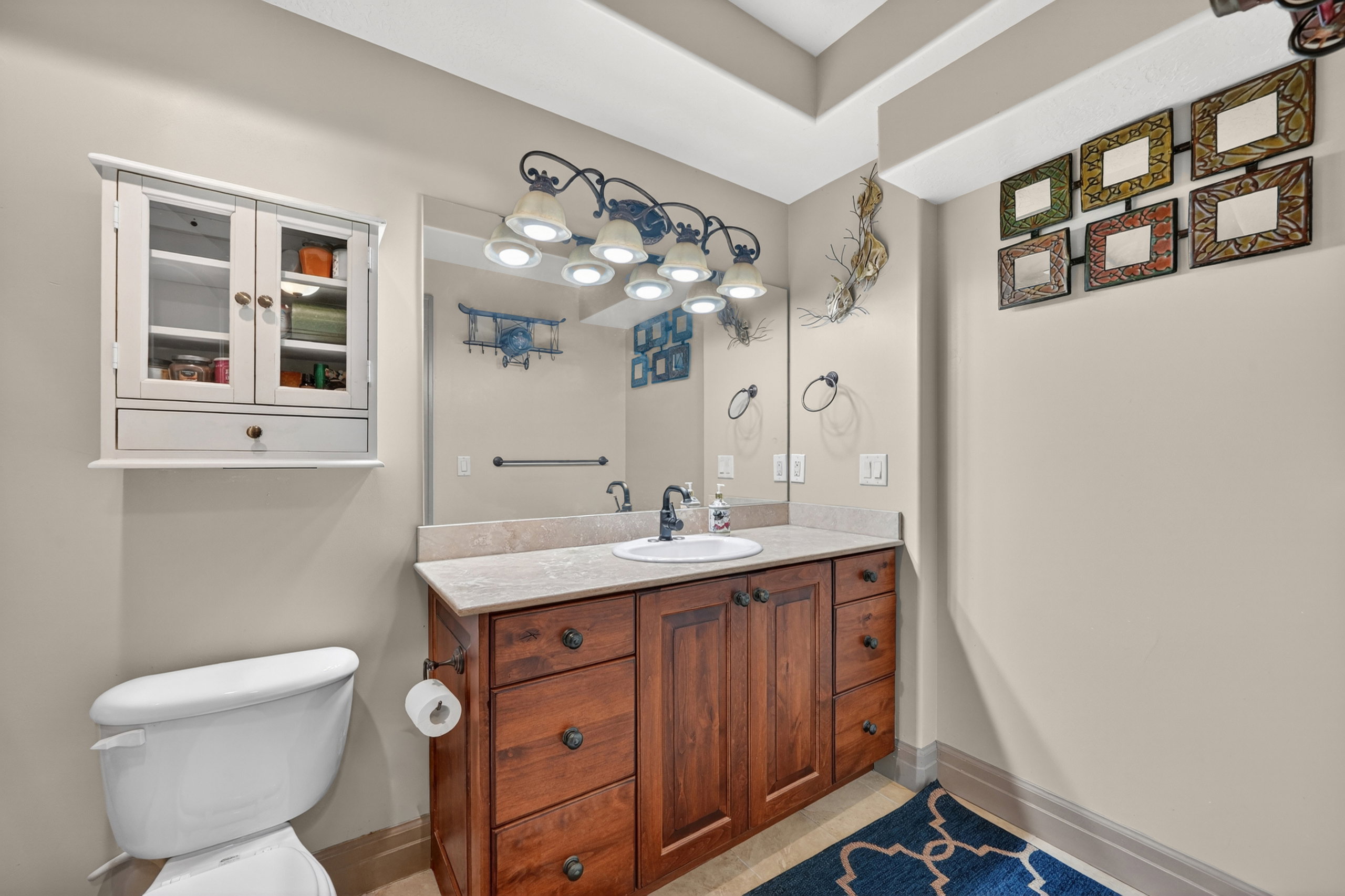 Vanity featuring wood cabinetry with multiple drawers and doors, a light-toned countertop, and an undermount sink
