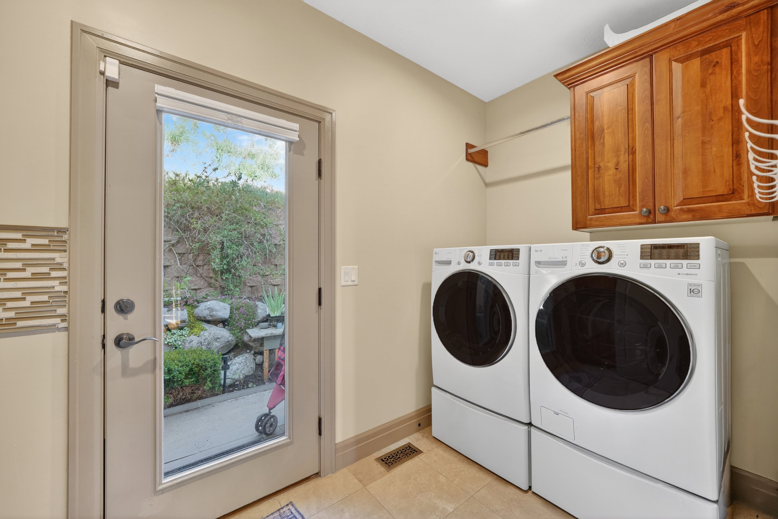 Laundry area with neutral wall paint, tile flooring, and a full-light exterior door