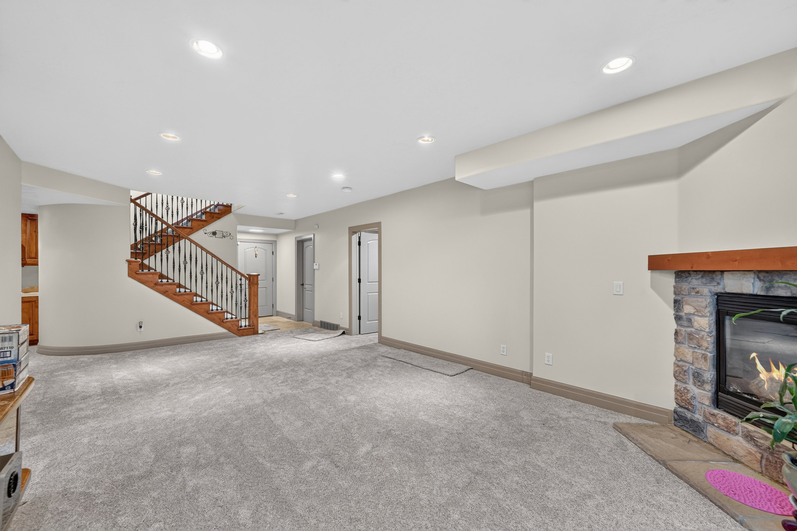 Spacious finished room featuring light gray carpeting and recessed lighting