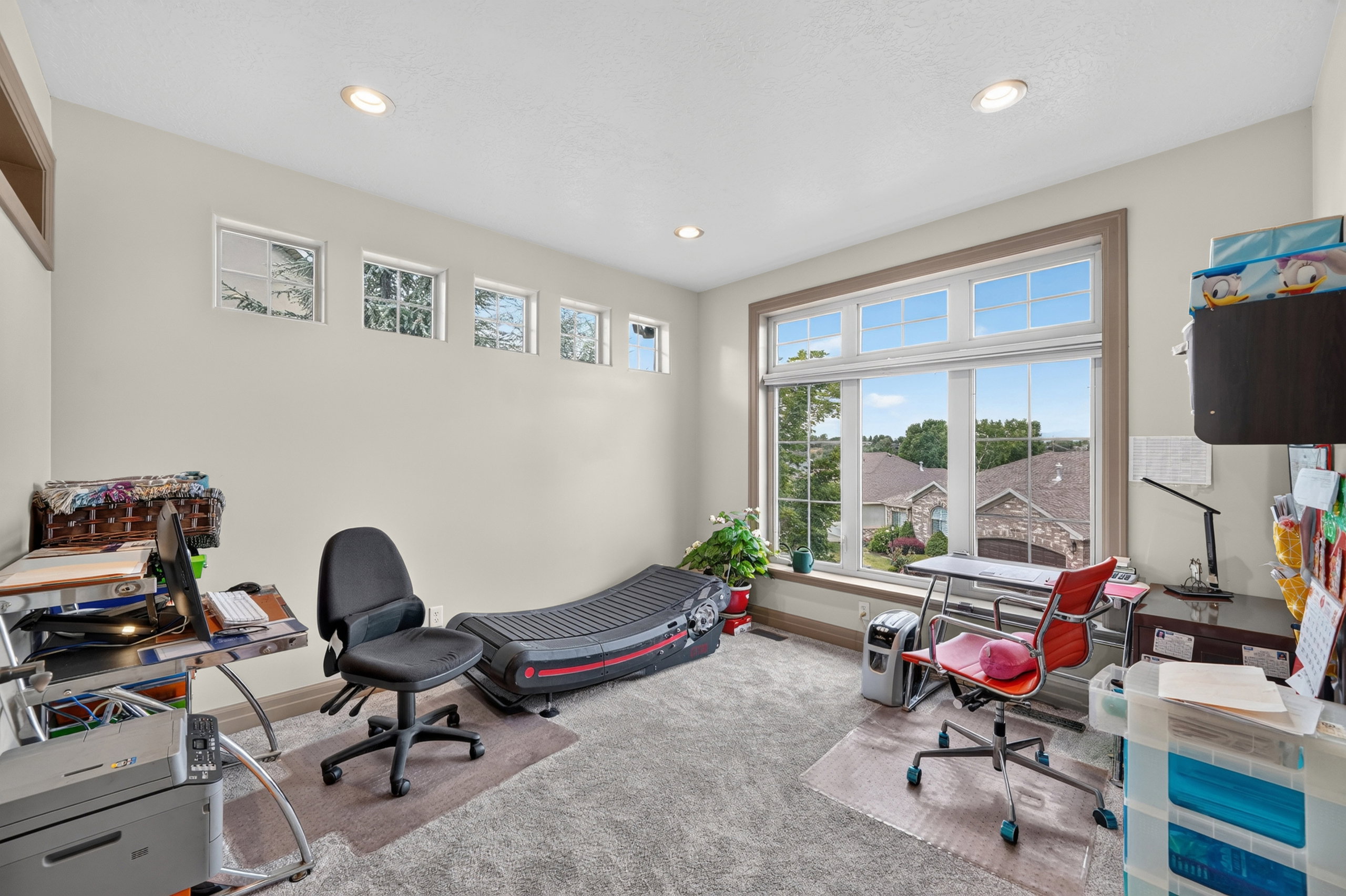 Room featuring extensive natural light from a large picture window and high transom windows