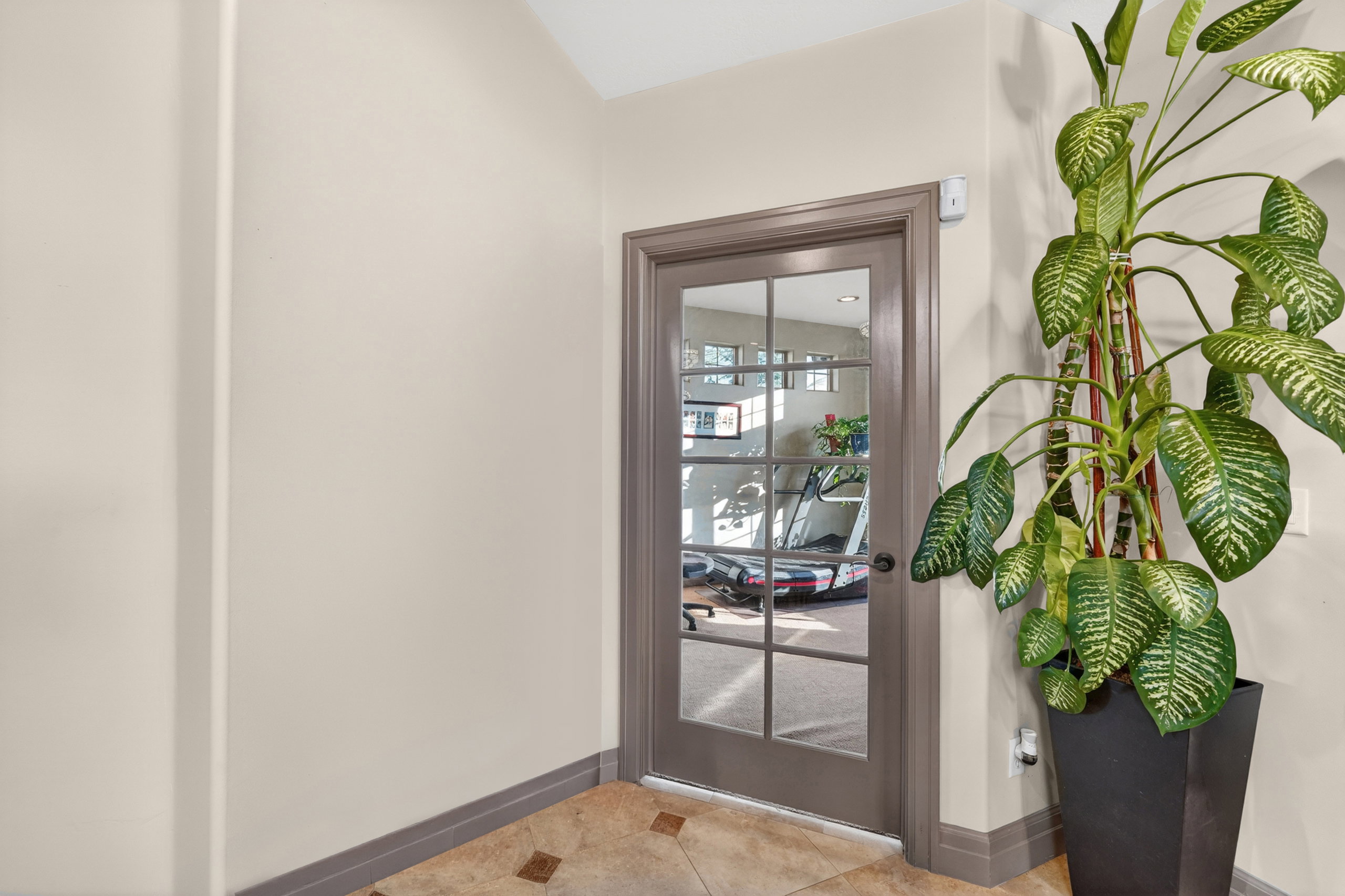 French-paneled glass door with gray trim and baseboard molding