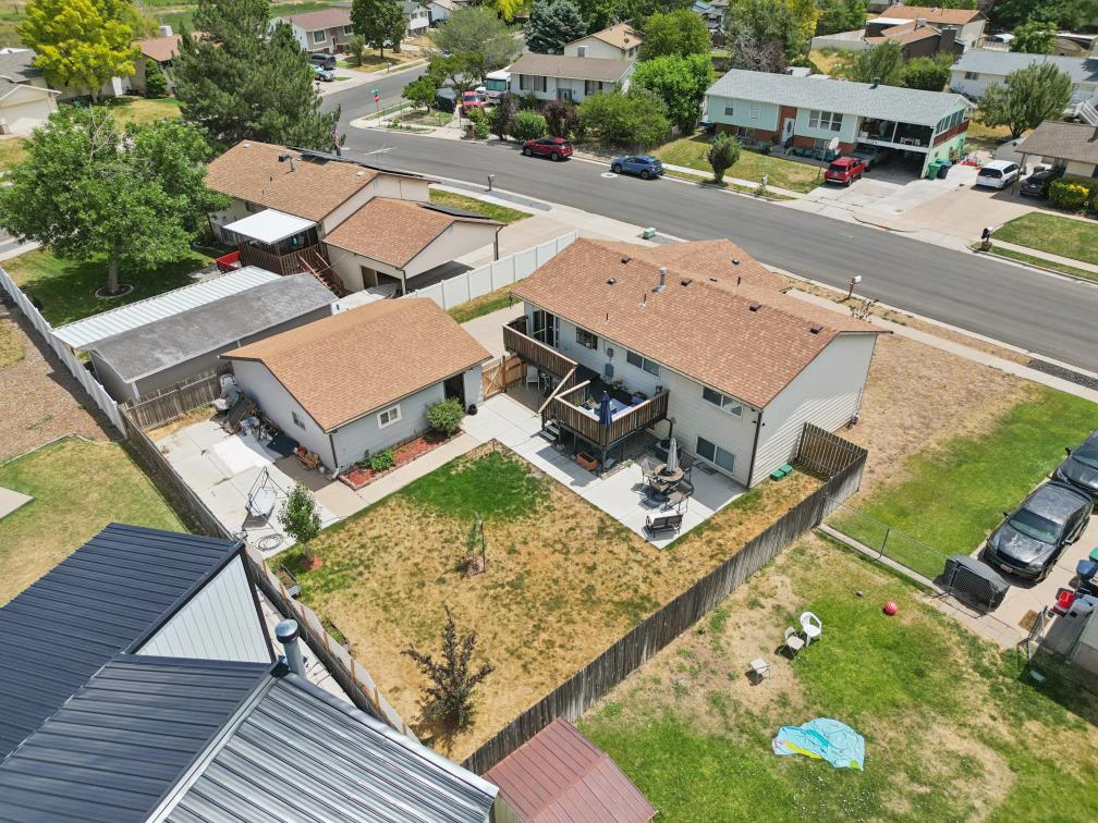 Rear exterior featuring a multi-level deck, concrete patio, and a fenced yard
