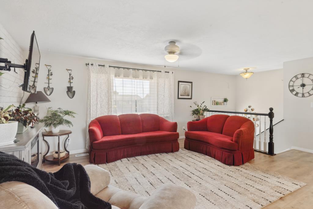Living area featuring light wood-finish flooring, white walls, and a ceiling-mounted light fixture