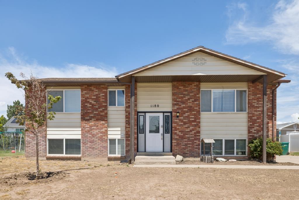 Brick and siding facade featuring a prominent entryway with a white front door and sidelights