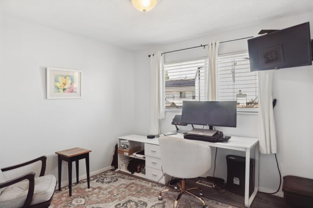 White walls, dual windows with blinds, and recessed lighting highlight this room
