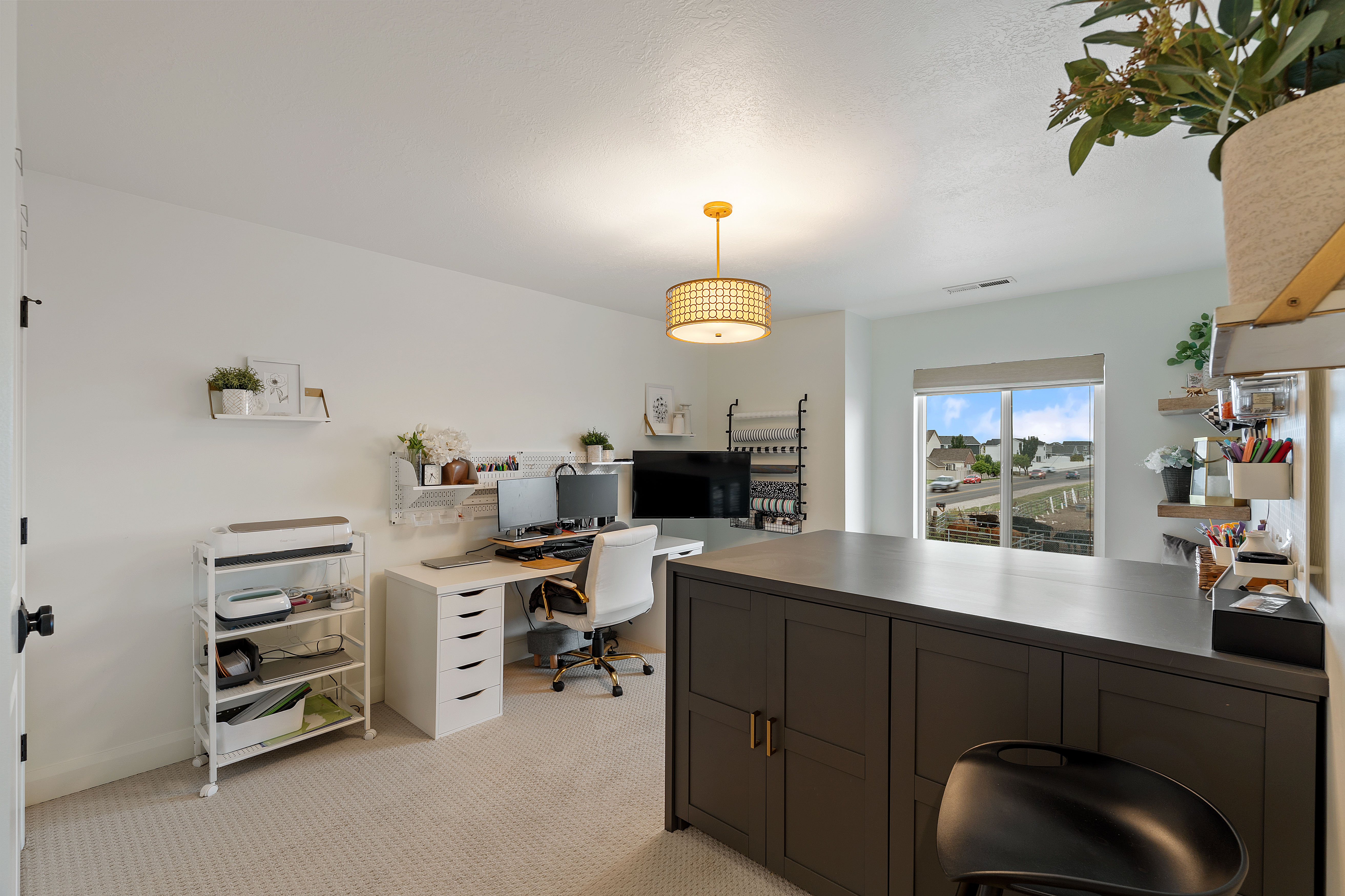 Spacious room featuring light-colored carpeting, a large built-in dark gray cabinet with gold hardware, and a sliding glass door