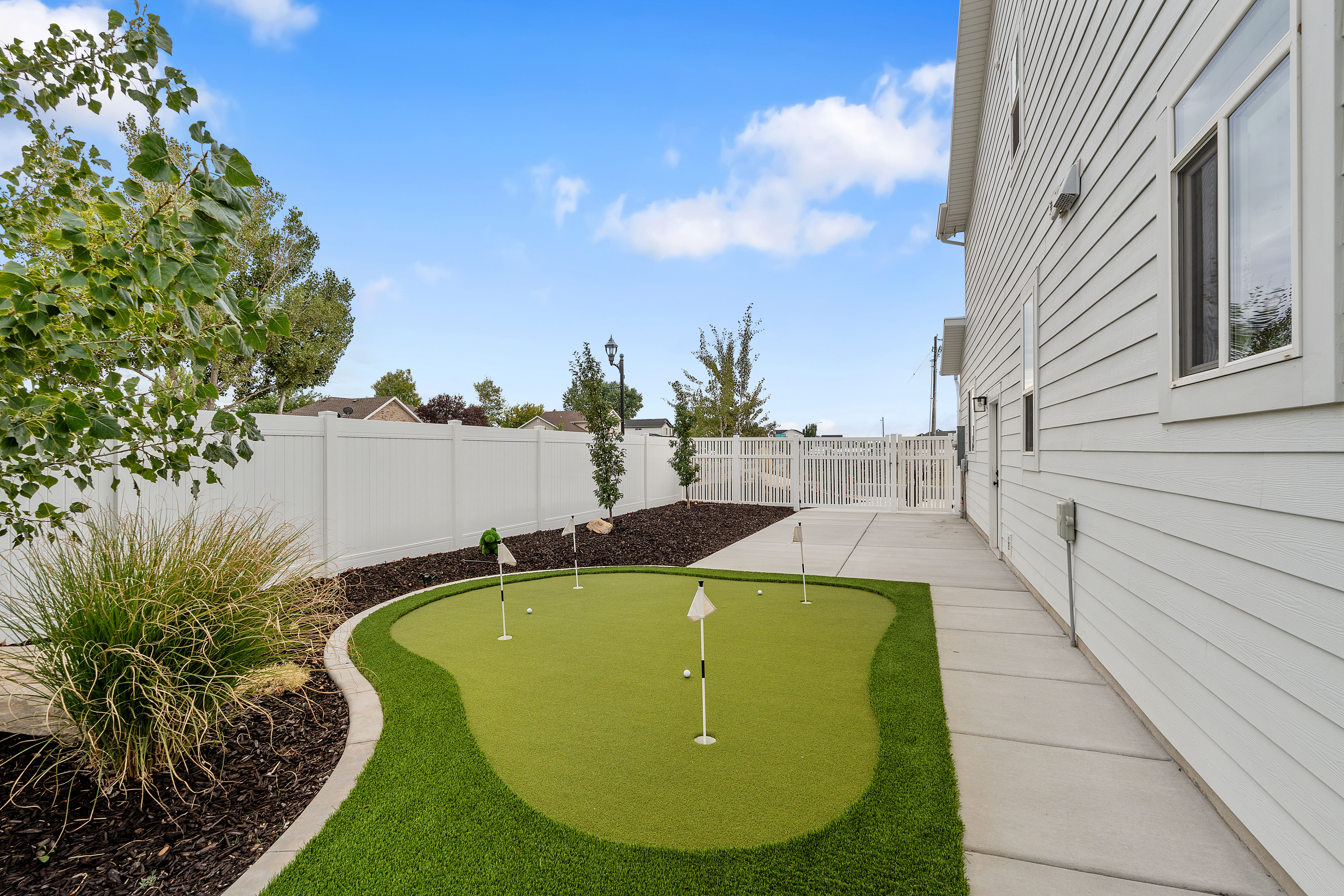 Outdoor putting green featuring multiple holes and a contrasting turf border