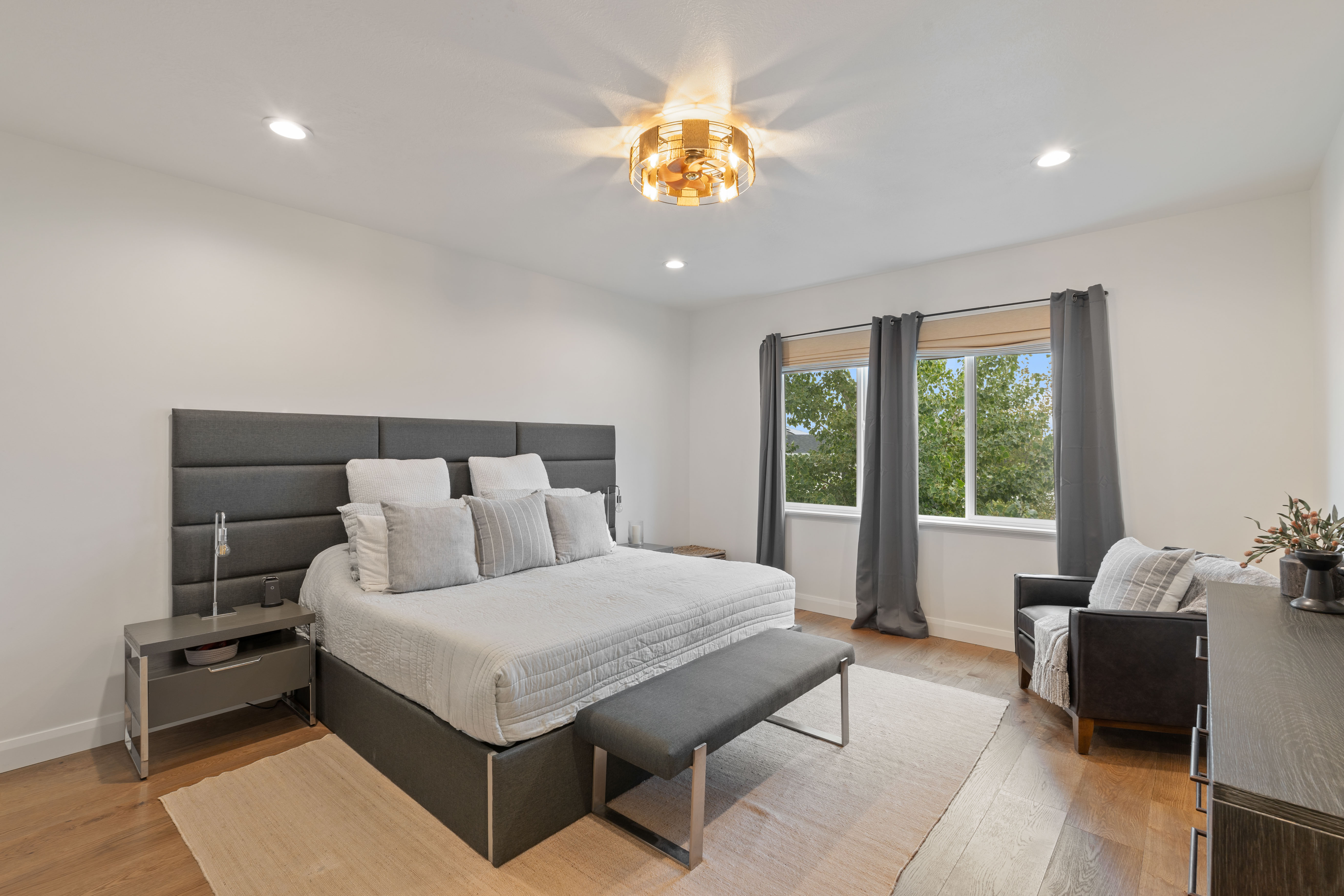 Master on Main Bedroom featuring wood-finish flooring, recessed lighting, and a contemporary chandelier