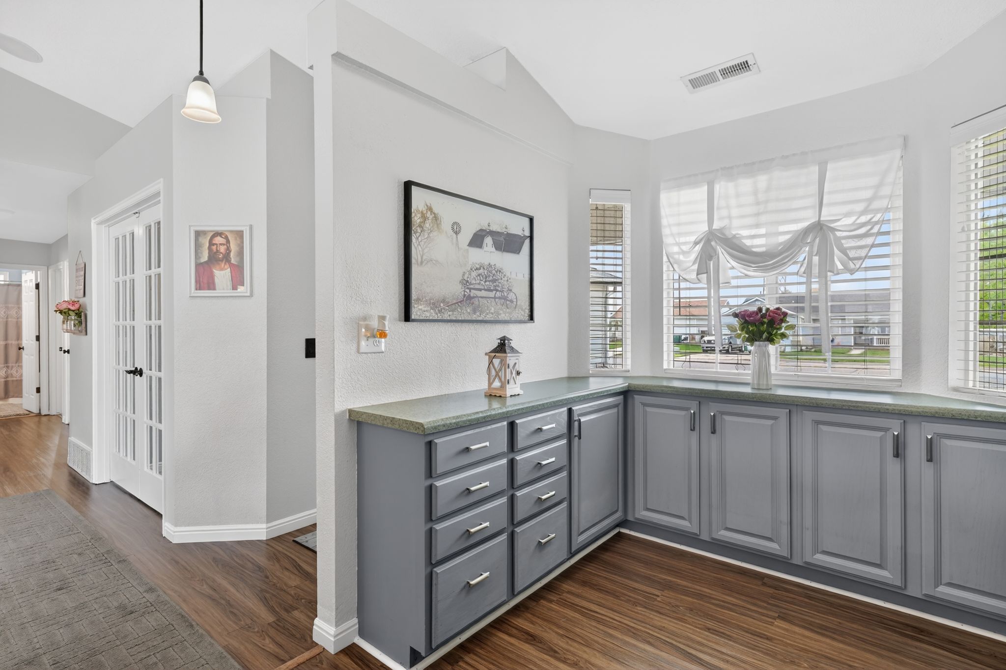 Built-in cabinetry with gray finishes and a light-toned countertop, complemented by wood-finish flooring