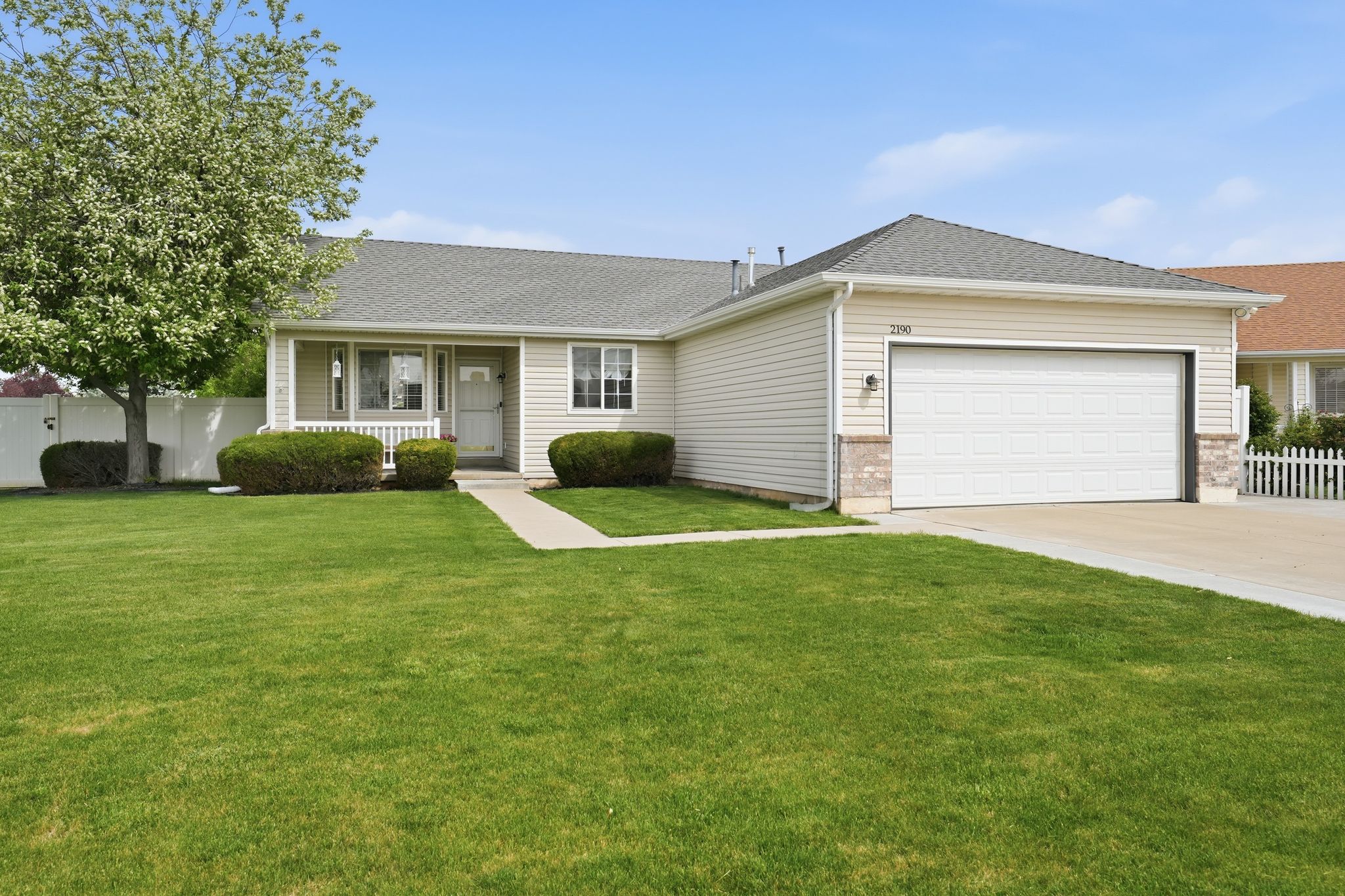 Ranch-style exterior with beige siding and a gray shingle roof