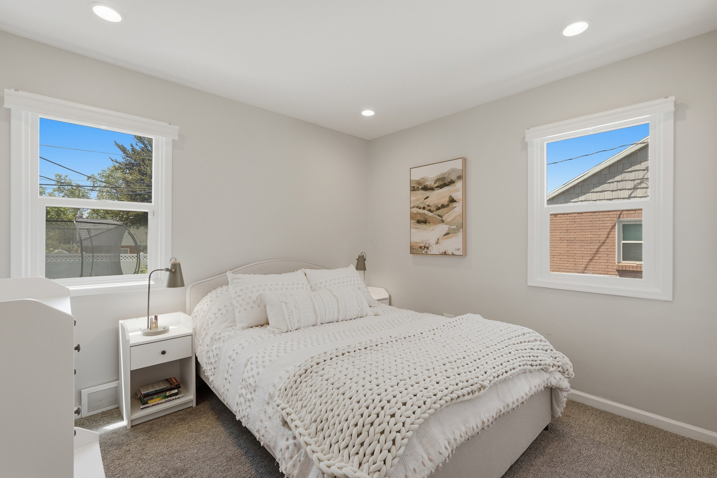 Bedroom featuring a neutral color palette, recessed lighting, two windows with white trim, and light gray wall-to-wall carpeting